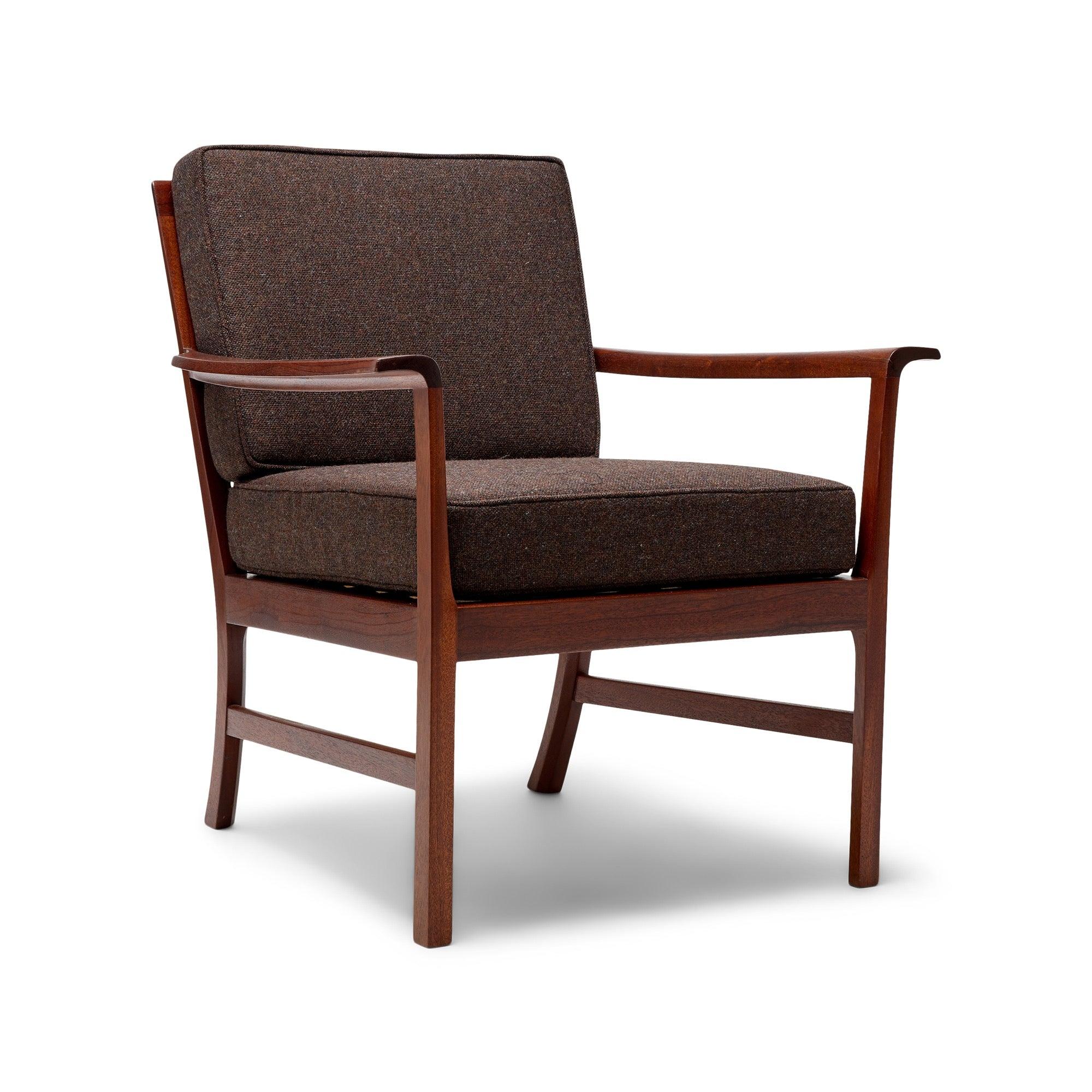 Un'elegante e generosa poltrona lounge con una struttura architettonica in mogano a vista e braccioli sagomati e discretamente curvati. Cuscini della seduta e dello schienale nuovi, in COM o in materiale come nuovo.