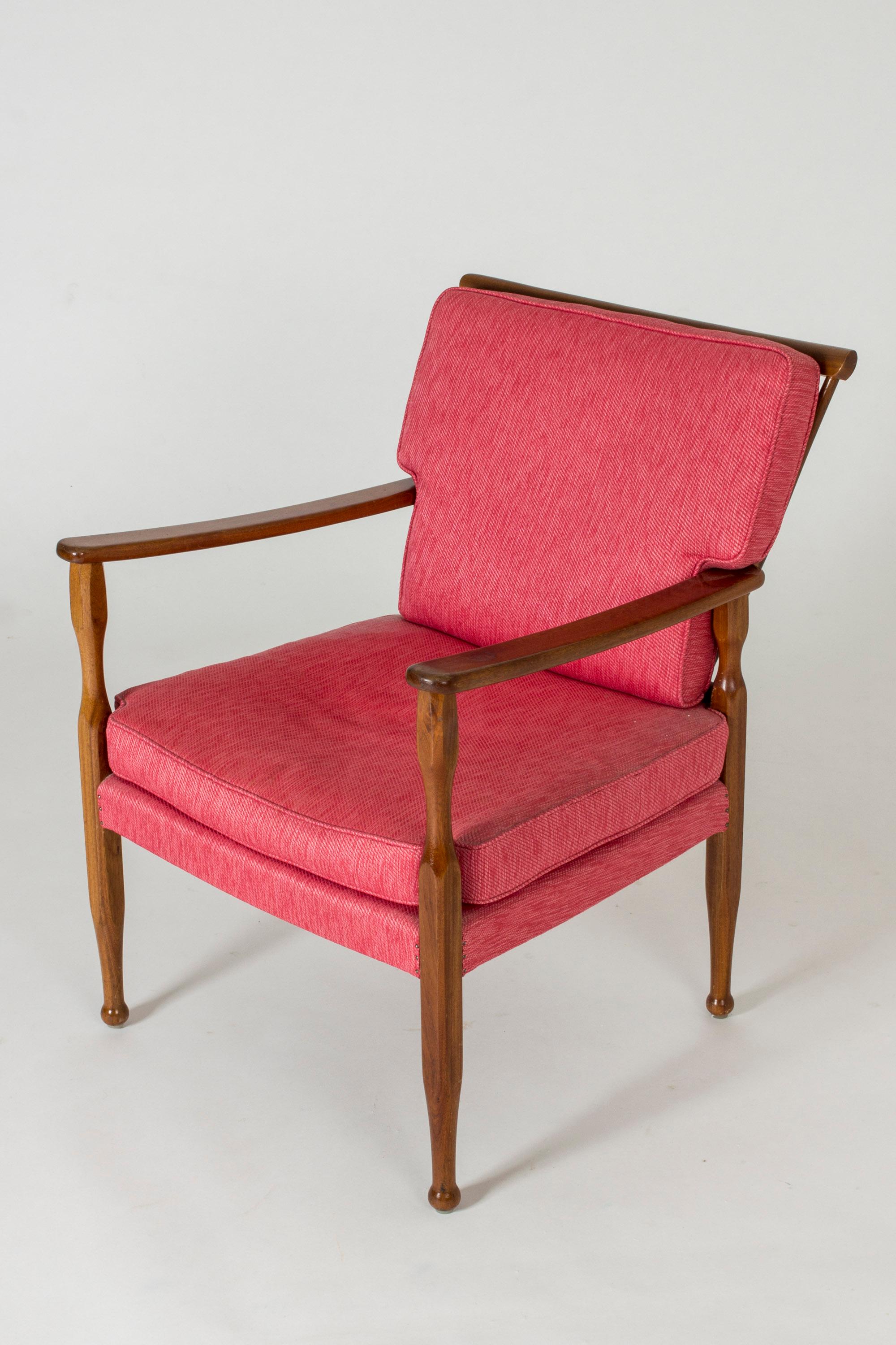 Elegant mahogany lounge chair by Josef Frank, with beautifully sculpted legs with knoblike feet. Warm, polished wood combines very nicely with the saturated pink upholstery.