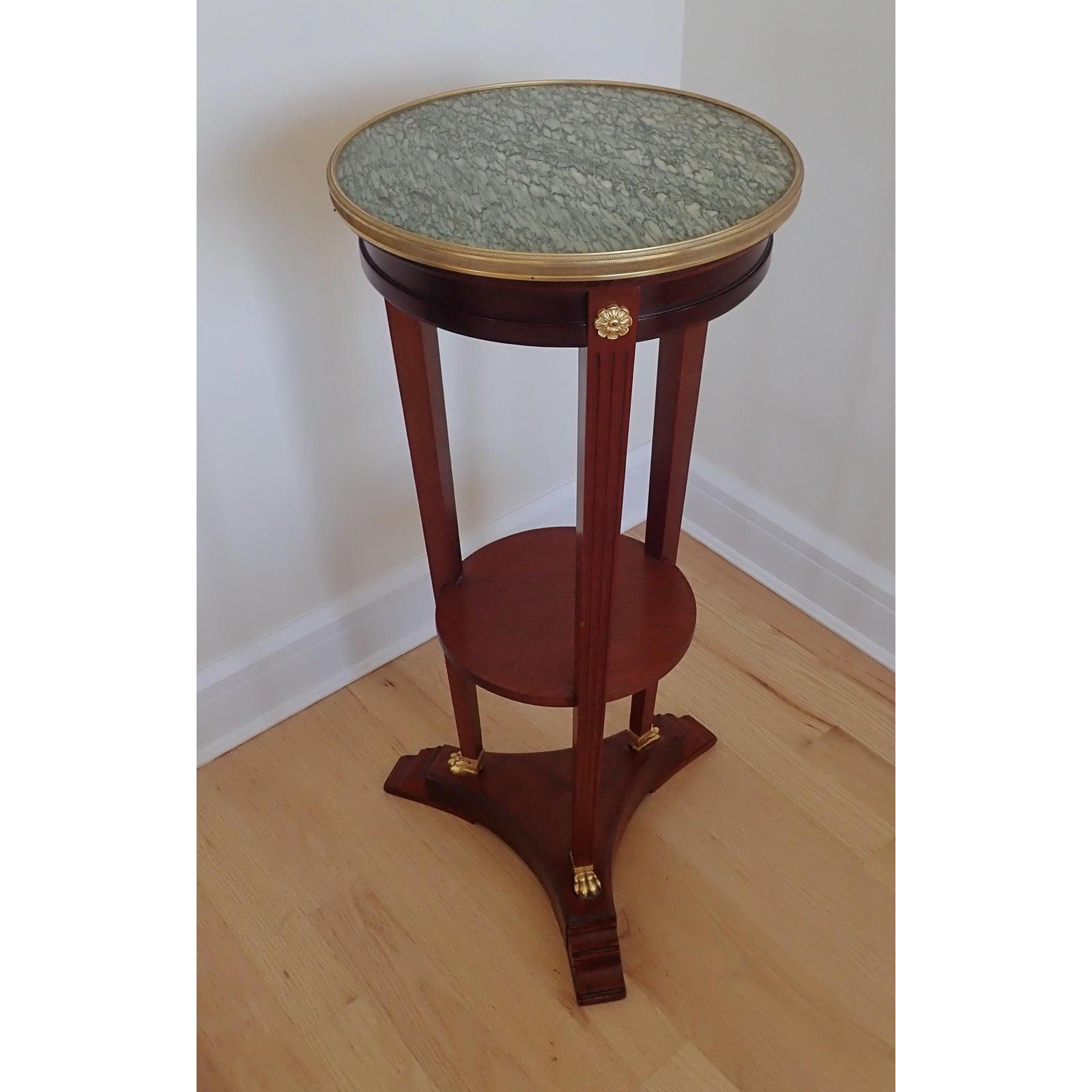 Mahogany Marble Top Pedestal. Marble top with Doré bronze gallery ring and feet . Height of shelf 15 1/2 inches. Triangular base approximately 19 inches. Diameter of shelf approximately 11 inches. less