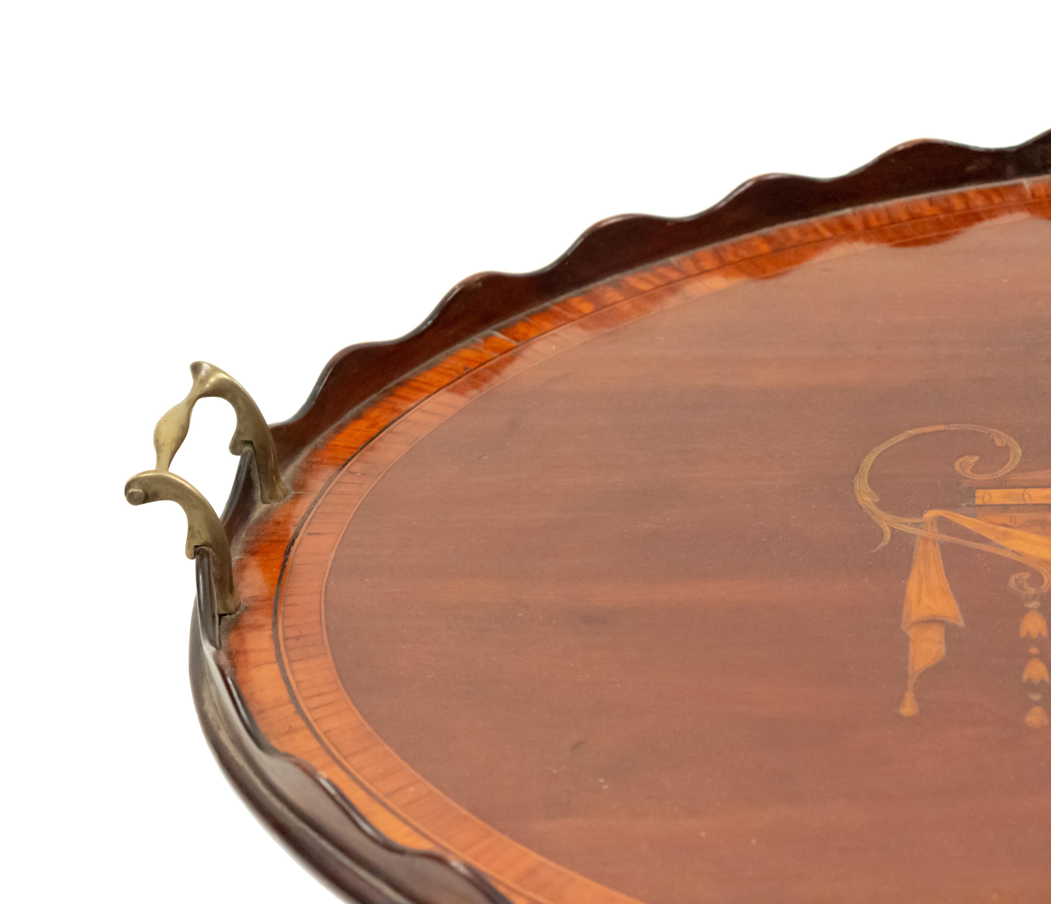 English Georgian mahogany oval tray (circa 1780) having a scalloped gallery top with satinwood marquetry depicting an urn with swags and curved brass handles.
  