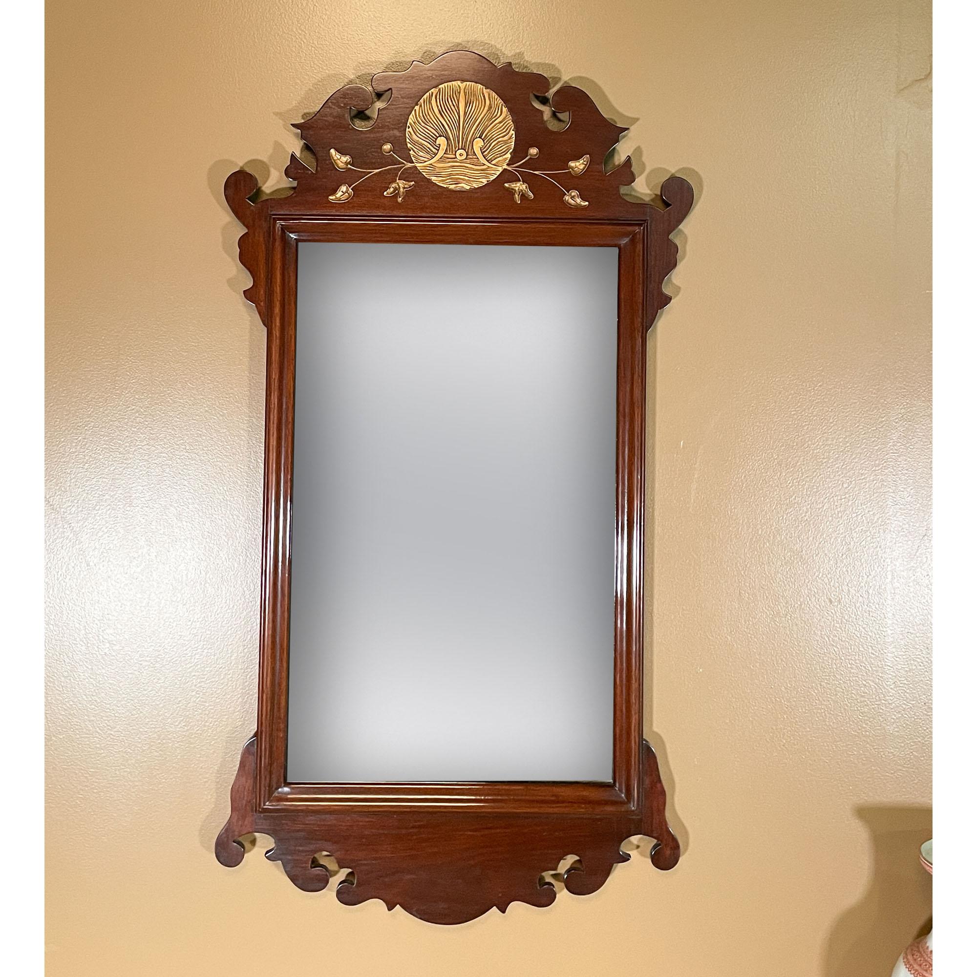 A Mahogany Mirror with Carved Top and Gold Leaf Details. This mirror has many elegant details throughout; including the original glass, the original finish, fantastic gold leaf work on the hand carved details along the top.

Everything on this