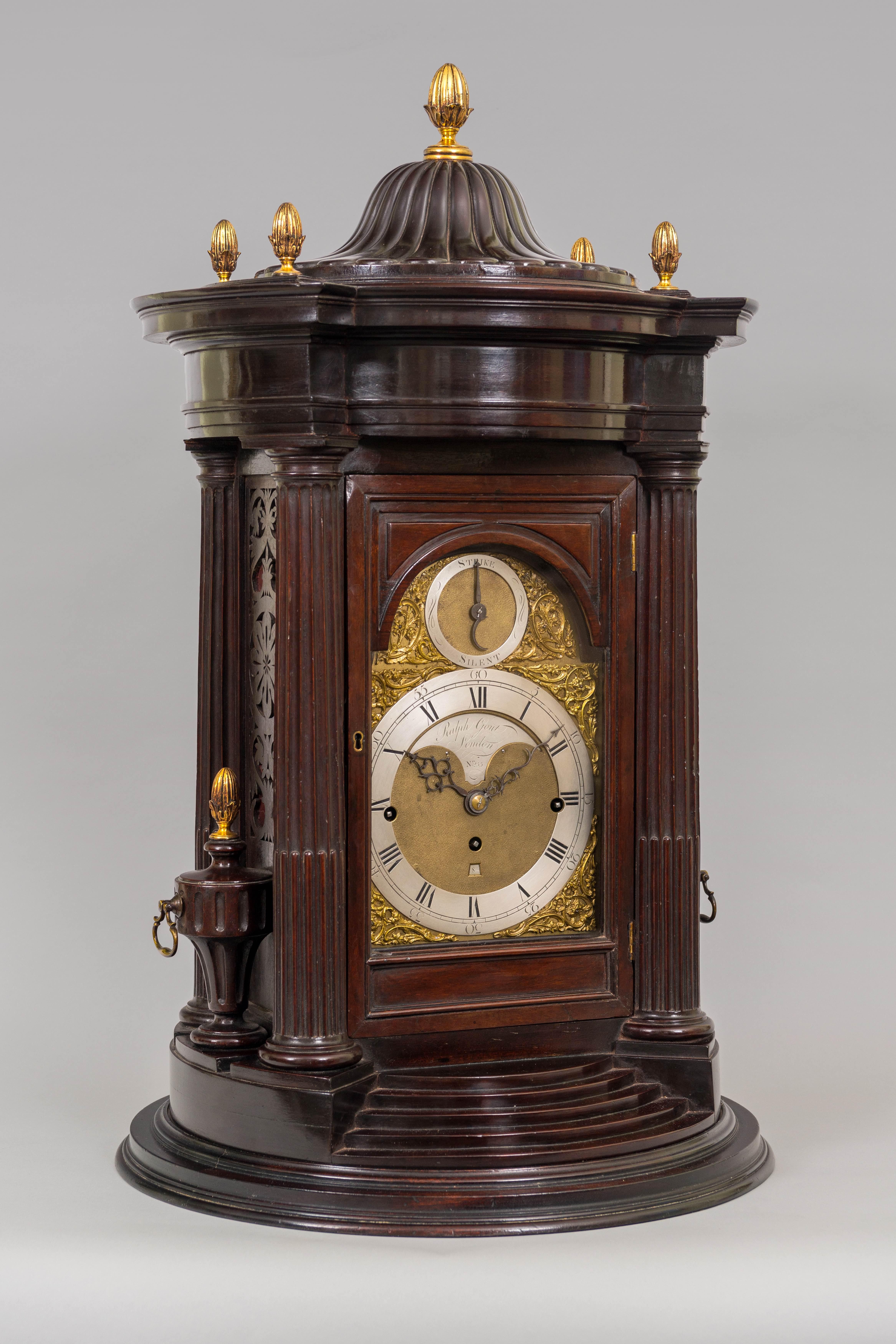 An impressive and unique 18th centur,y, GeorgeIII period antique circular mahogany musical table clock, in a case of neoclassical design by Ralph Gout of London.
 
The substantial mahogany case has four fluted and capped columns with matching side