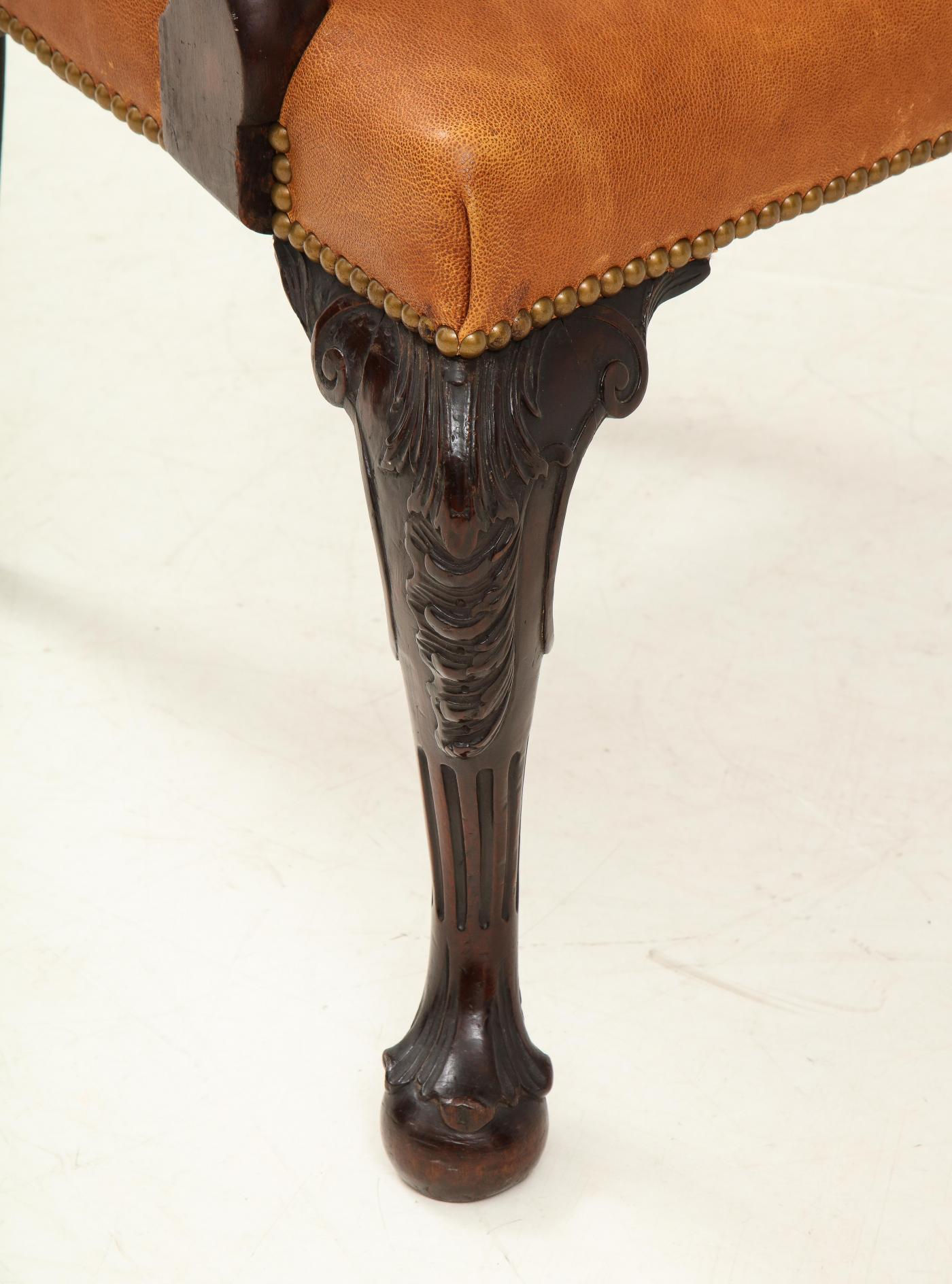 A suberb George II/III carved mahogany open armchair having a carved crest rail over an open carved back splat, upholstered seat with cabriole legs terminating in an unusual ball foot. The fluting on the legs is similar to fluting found on chairs