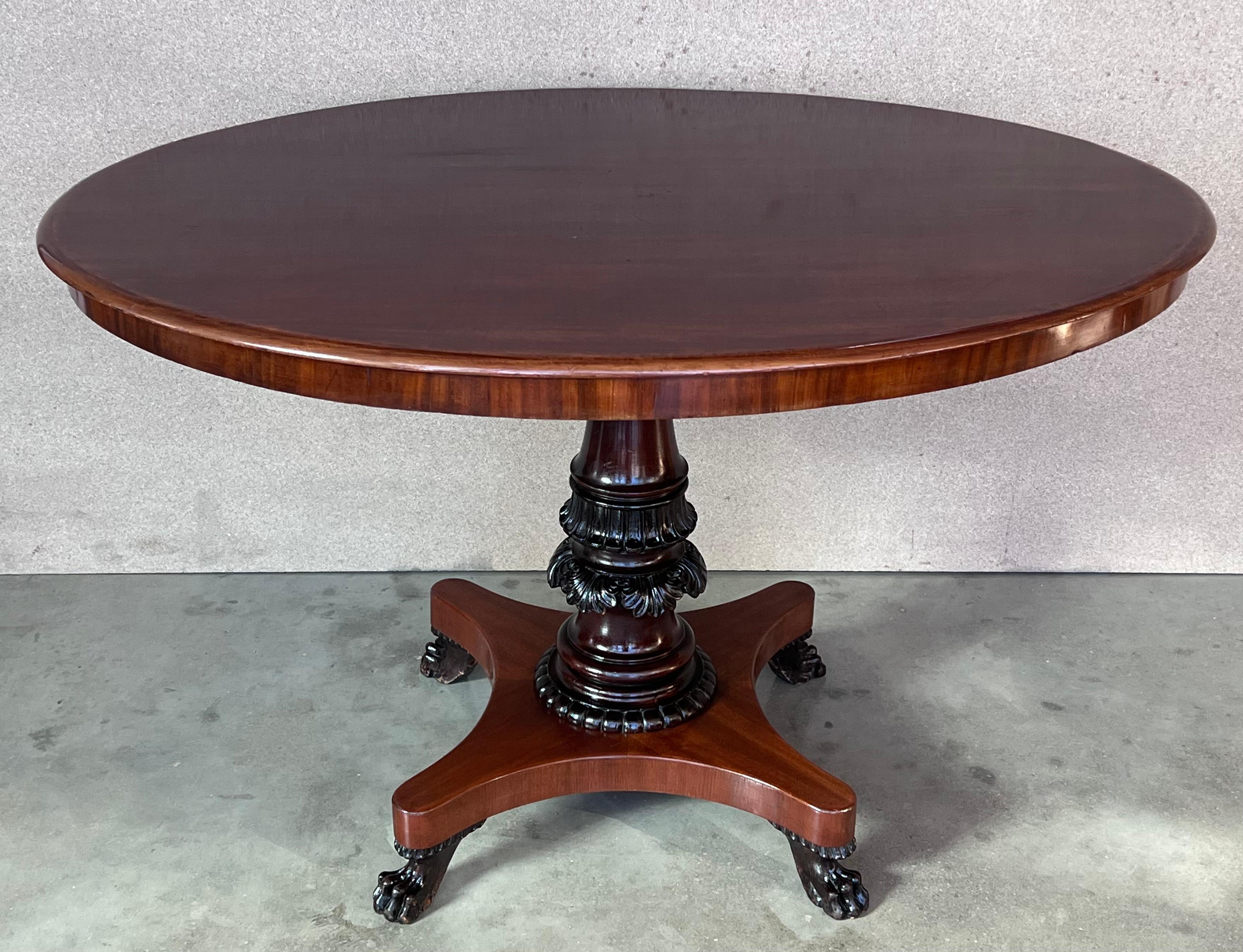 We present you this piece of furniture made of solid mahogany wood and partially veneered with pyramidal mahogany. The whole is dated the second half of the 19th century. The oval table top is supported on a massive, turned and carved pedestal,