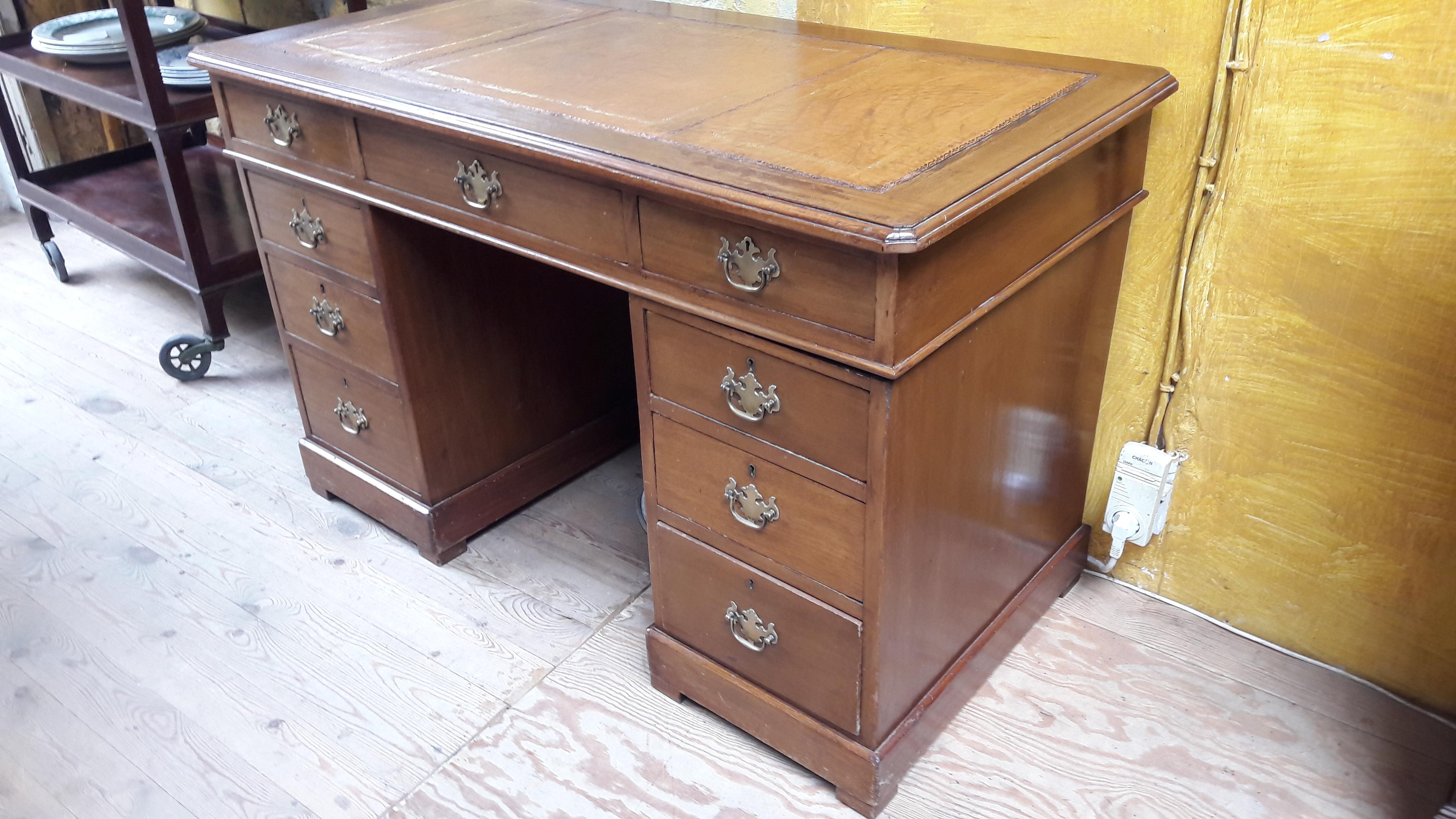 Small pedestal desk with new tan leather. A good quality 1970s English reproduction desk in Georgian style with brass Queen Ann handles.
This desk is in three pieces: a top and two pedestals.
The leather can be changed in other color (with a