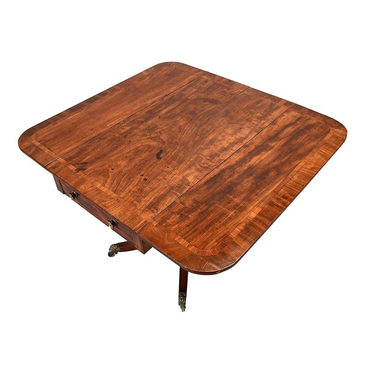 Table Pembroke en acajou anglais sur un socle tourné. Le plateau d'acajou bien structuré est rectangulaire avec des coins arrondis et une bande de marqueterie sur tout le pourtour. Il y a un tiroir à chaque extrémité, tous deux avec des boutons en