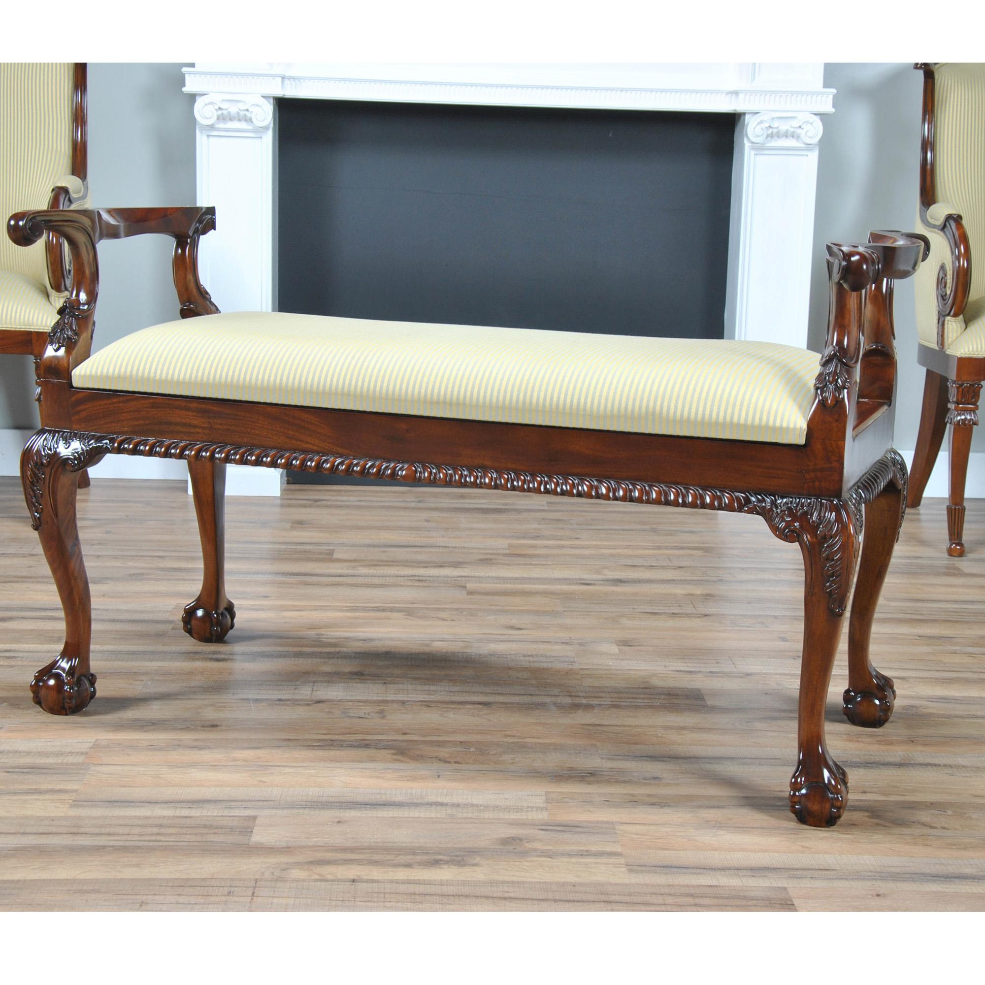 A Mahogany Piano Bench is produced from solid mahogany with hand carved details all the way from the scrolled arms to the gadrooned (rope edged) skirt and on downwards to the cabriole legs which feature acanthus carvings as well as ball and claw