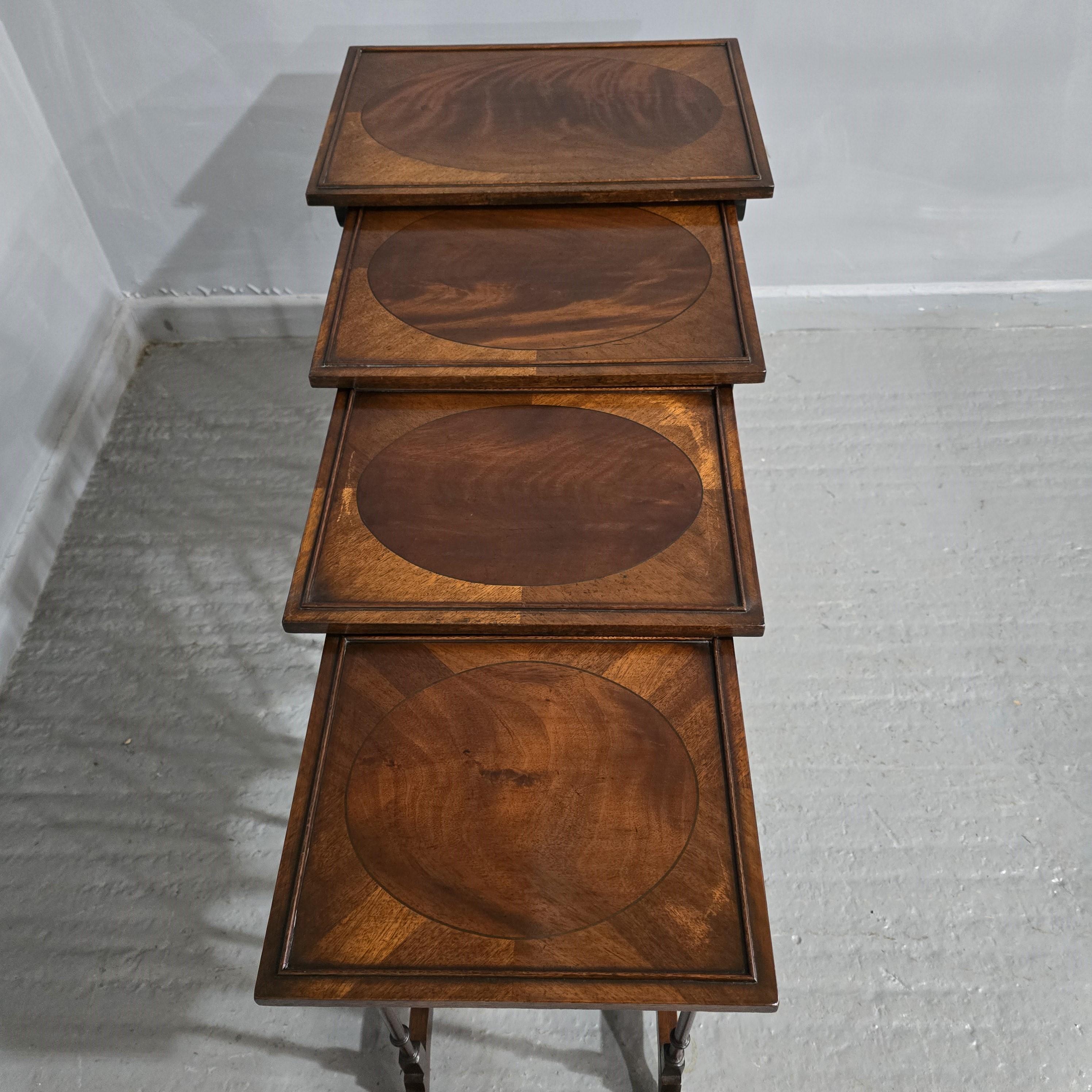 Excellent quality and condition set four mahogany inlaid nest of tables with faux bamboo legs and bowed stretcher, inlaid oval panel to the top.

28