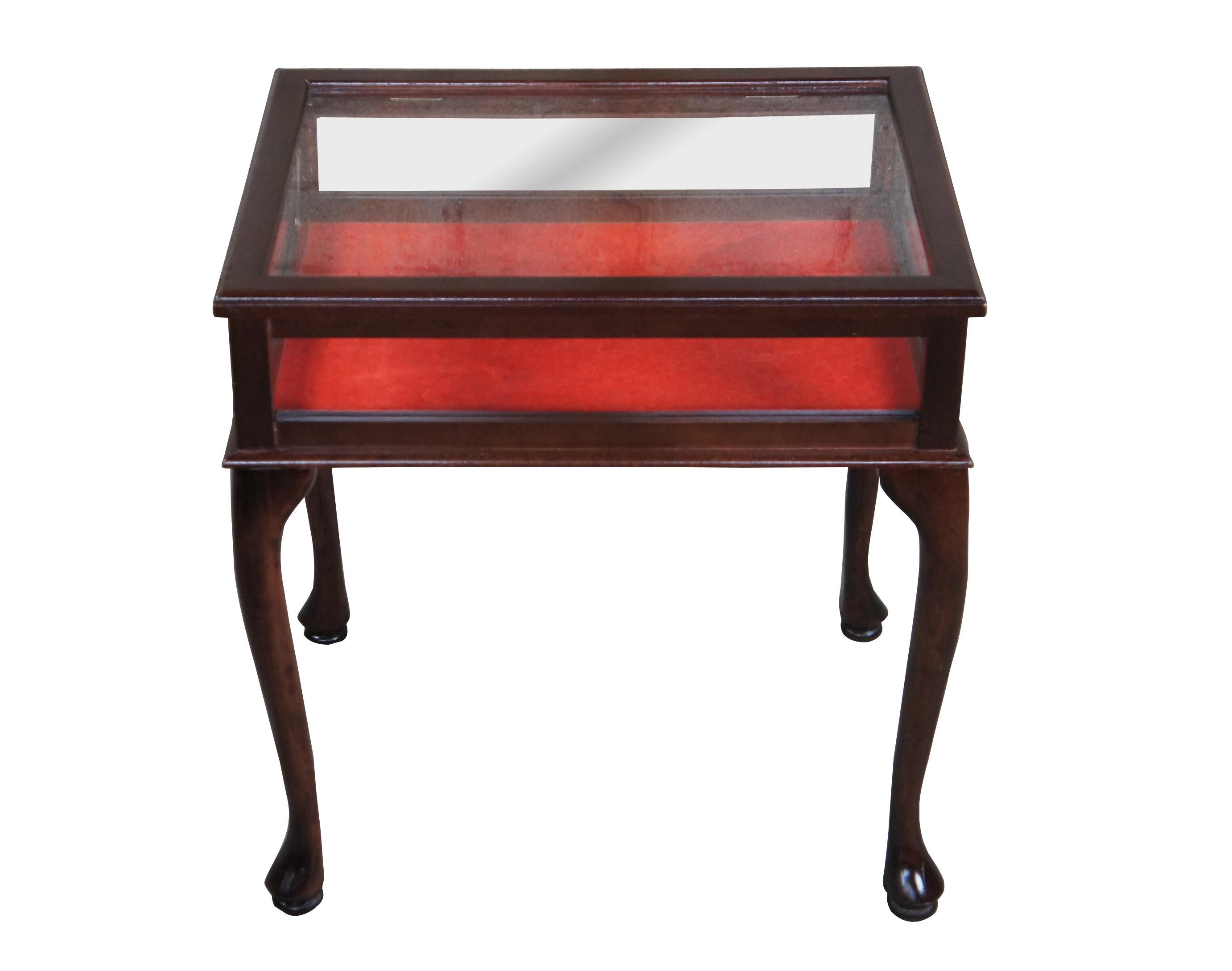 Vintage Queen Anne style Bijouterie / Vitrine / Curio Display table.  Made of mahogany featuring glass sides and top with red felt insert and serpentine legs.

Dimensions: 
23