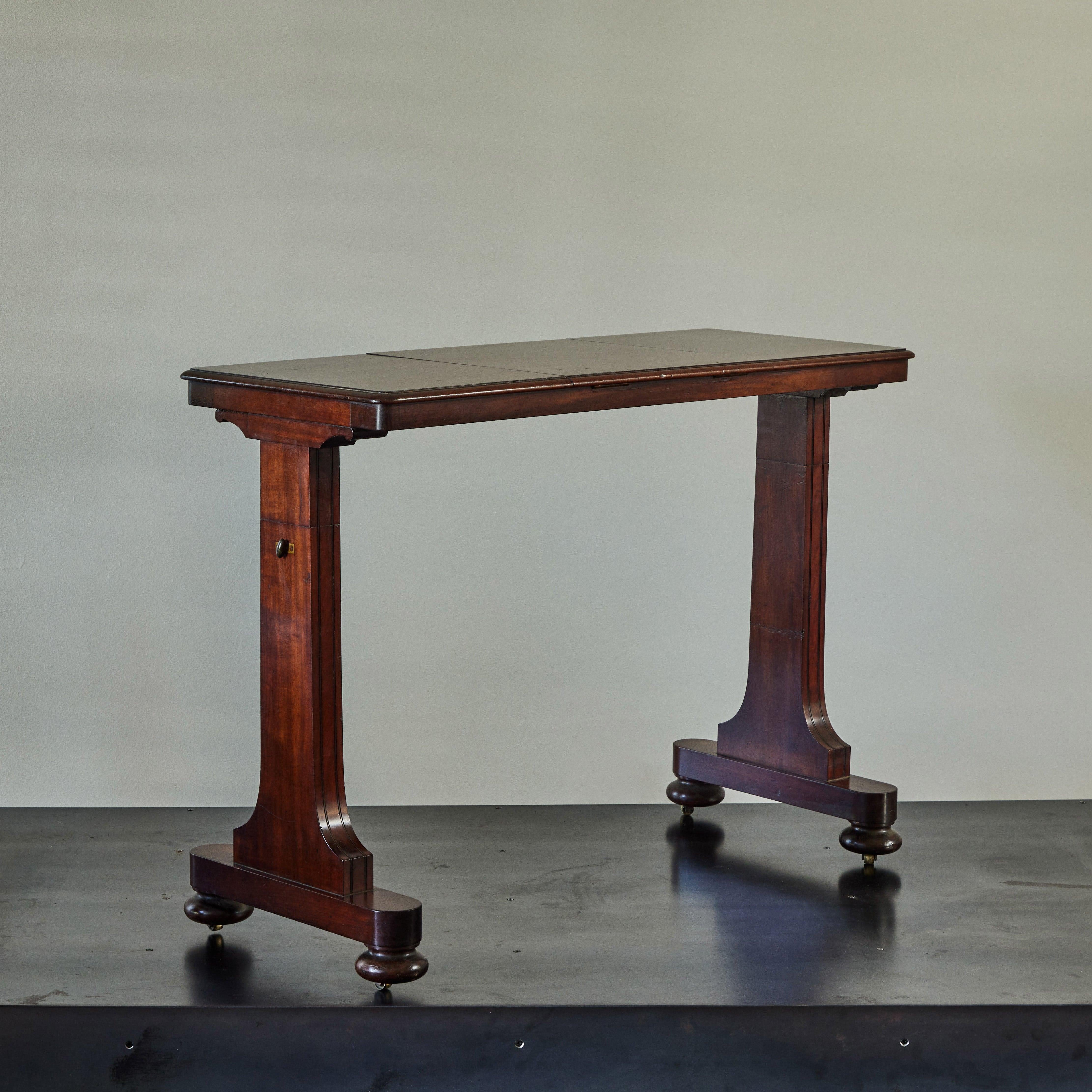 19th century English mahogany reading table. With its excellent proportions and charming function, this piece of Victorian craftsmanship could make a reader out of anyone. 

England, circa 1850

Dimensions: 40W x 15D x 31H.