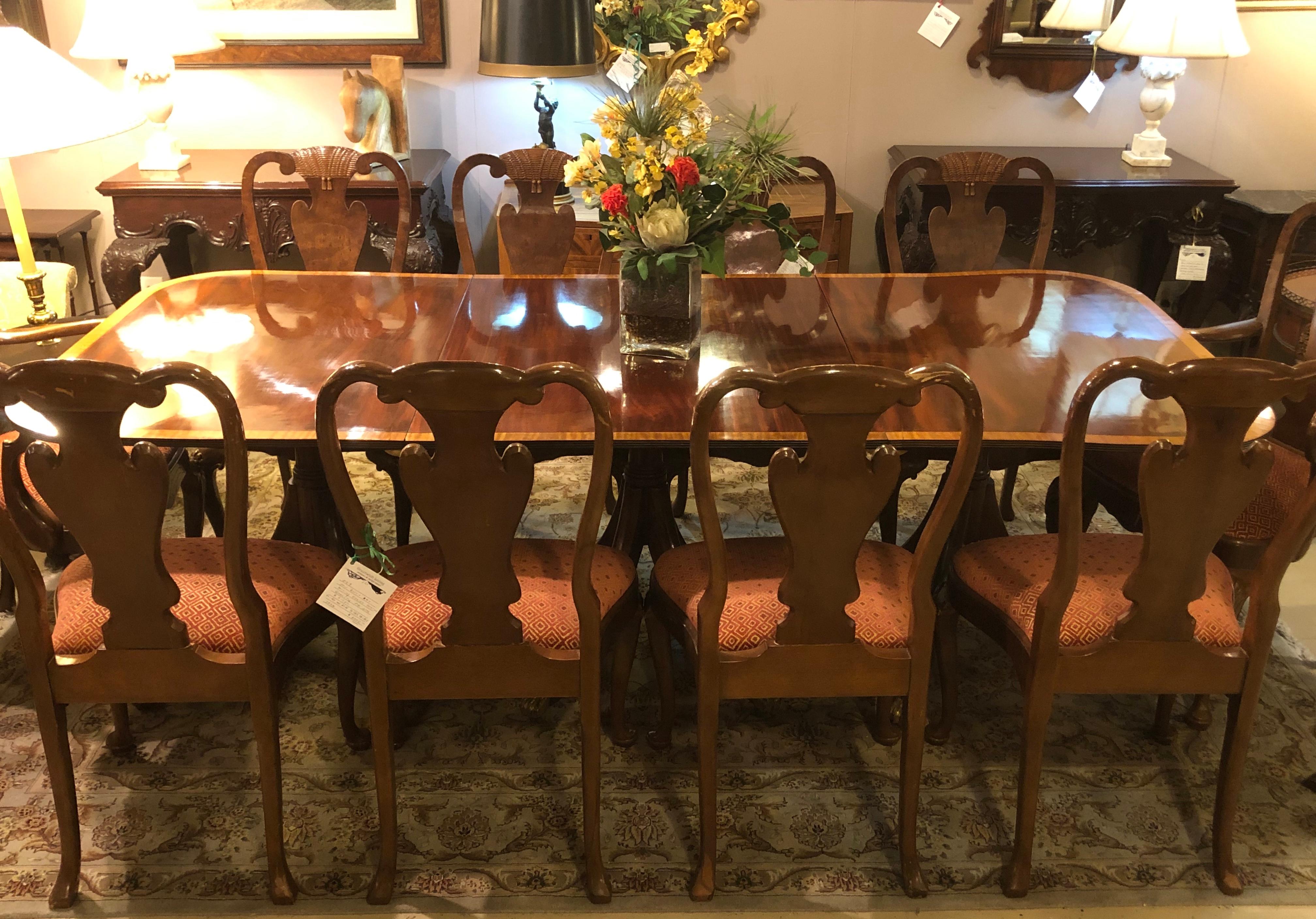 Mahogany satinwood banded Georgian style triple pedestal dining table having two 20 inch leaves. This fine recently hand rubbed French polished dining table sits on a quad leg centre support flanked by two tr-legged column form supports all on claw