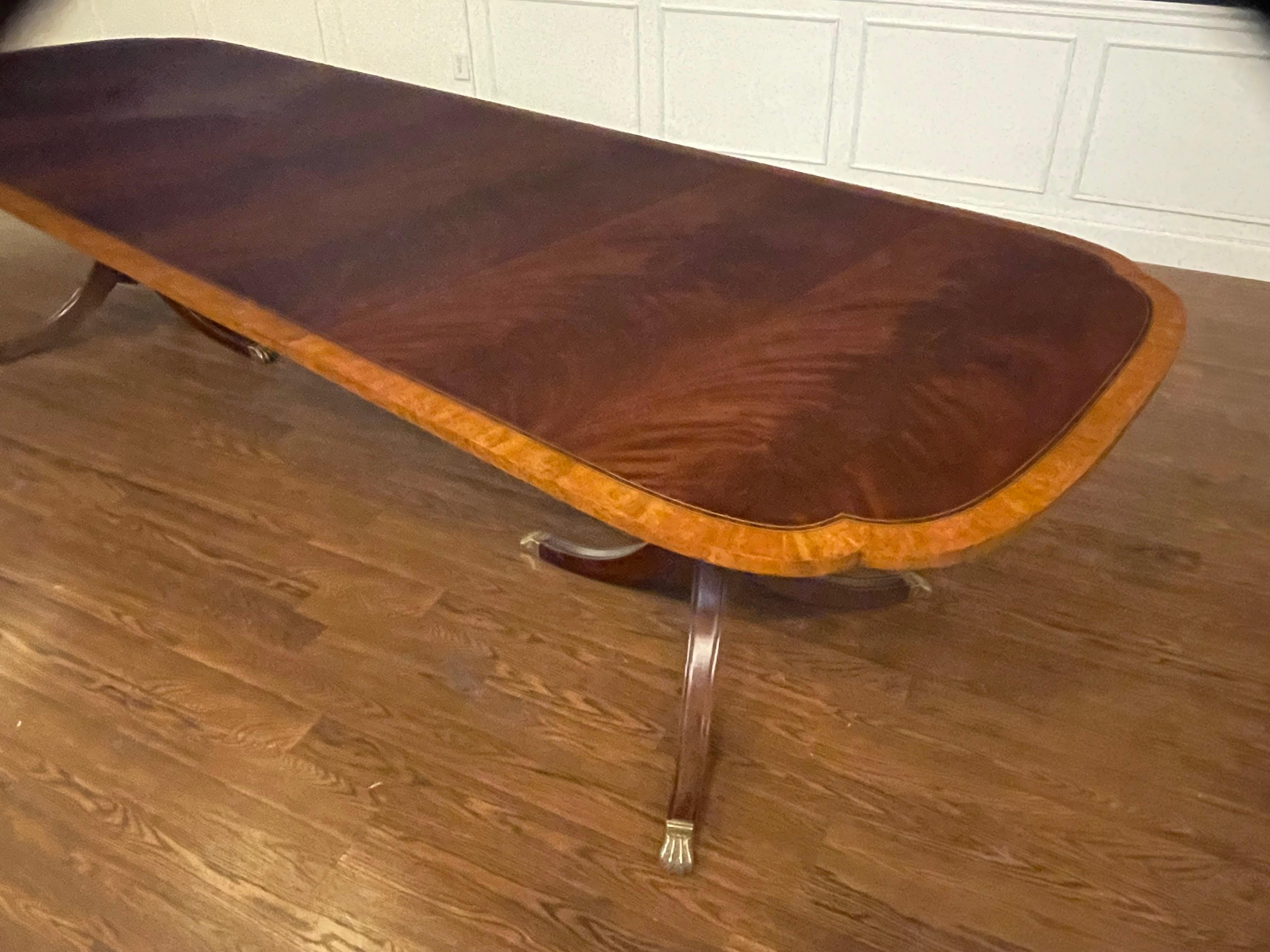 This is our traditional mahogany scallop cornered dining table. The highlight of this table is the elegantly shaped scalloped corners. It features a field of slip-matched swirly crotch mahogany from West Africa and a satinwood border from South