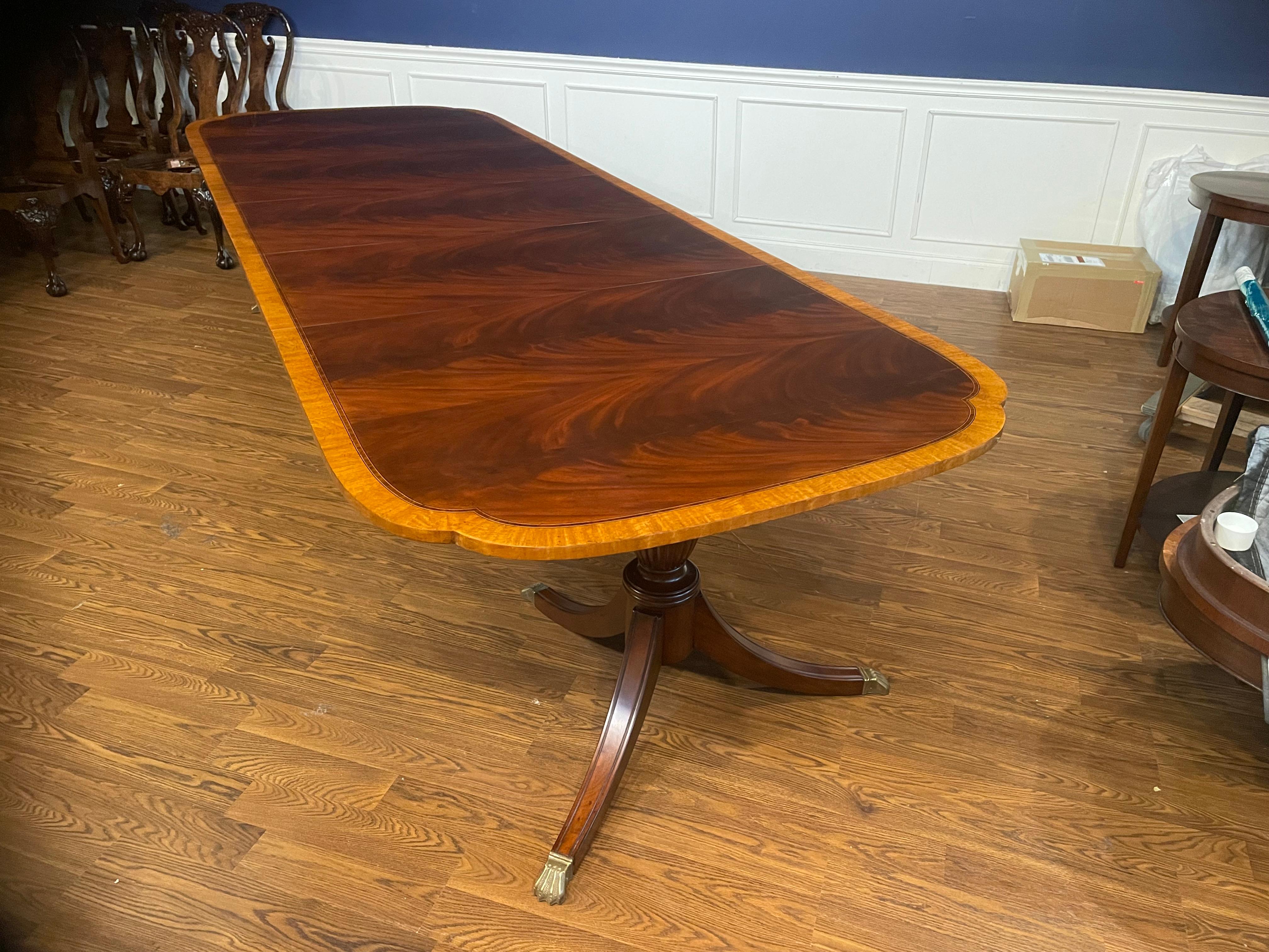 This is our traditional mahogany scallop cornered dining table. The highlight of this table is the elegantly shaped scalloped corners. It features a field of slip-matched swirly crotch mahogany from West Africa and a satinwood border from South