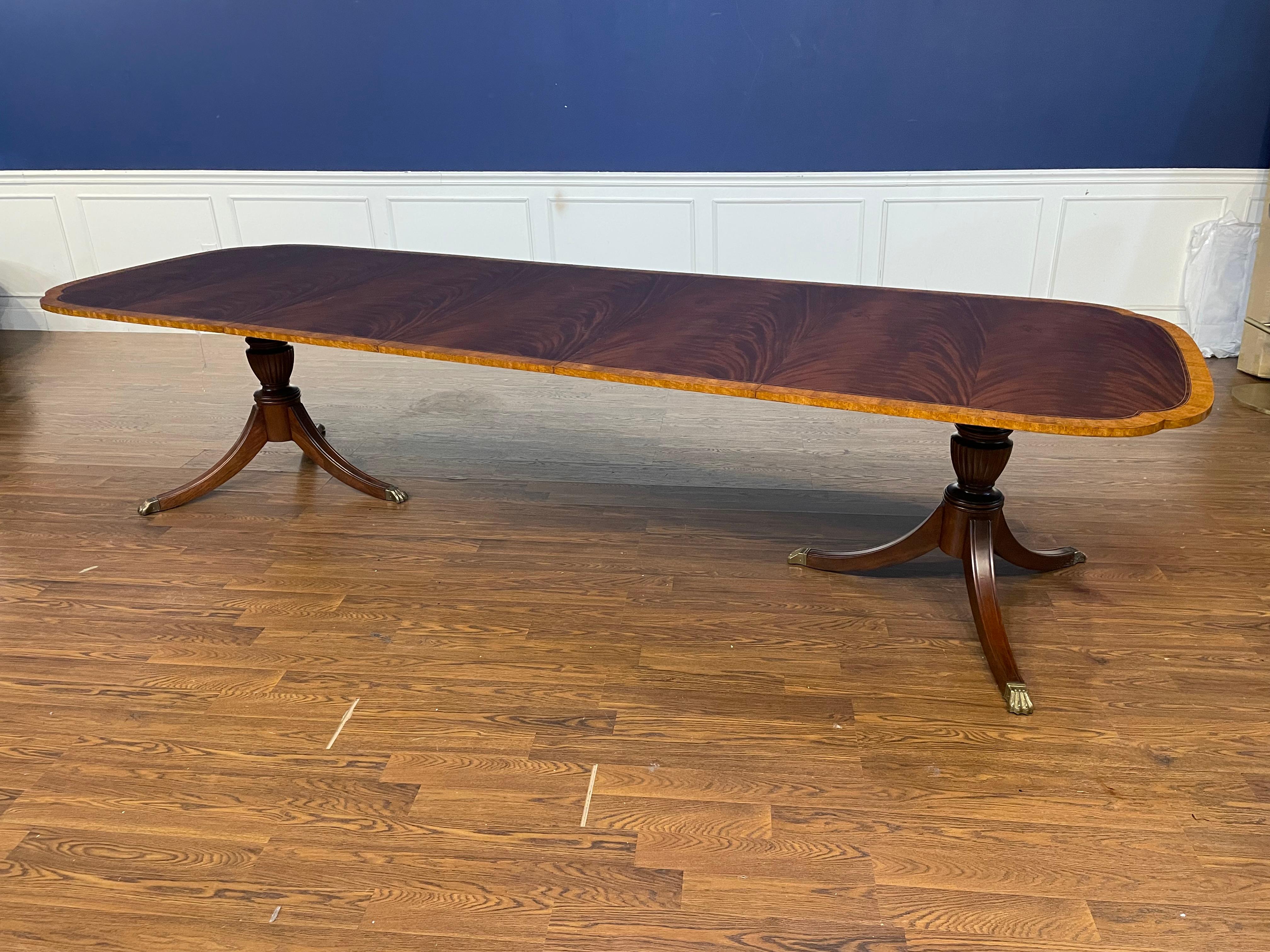 This is our traditional mahogany scallop cornered dining table. The highlight of this table is the elegantly shaped scalloped corners. It features a field of slip-matched swirly crotch mahogany from West Africa and a satinwood border from South