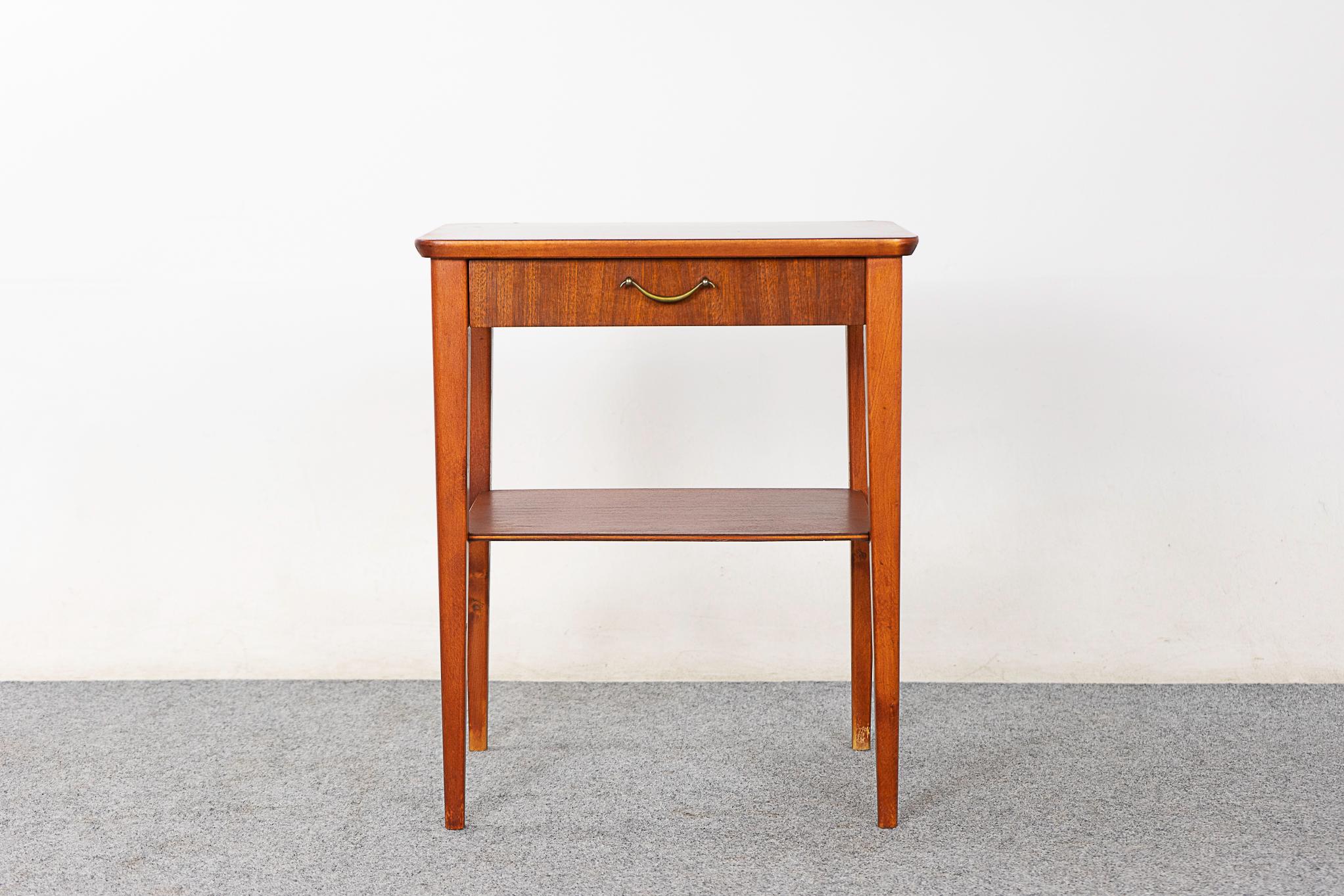 Mahogany mid-century bedside table, circa 1960's. Elegant slender legs, beautifully veneered top and a sleek drawer.