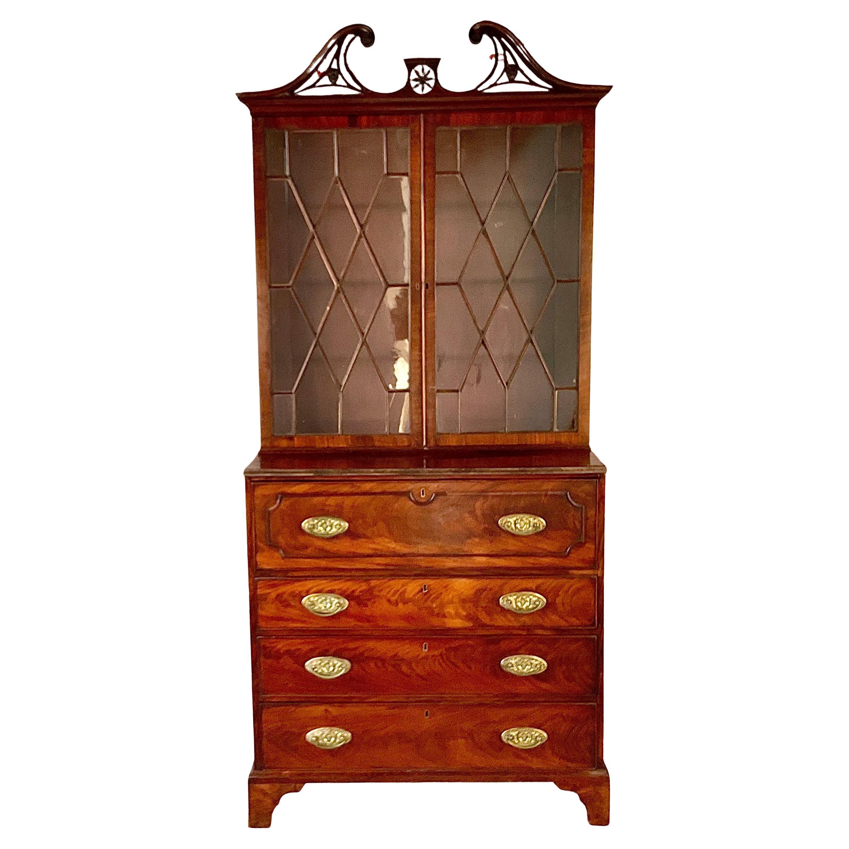 Early 19th Century George III Mahogany Secretaire Bookcase. Bookcase features a broken swan-neck pediment with fretwork design, above a molded cornice. The upper cabinet features two glazed doors with astragal mullions forming a diamond lattice