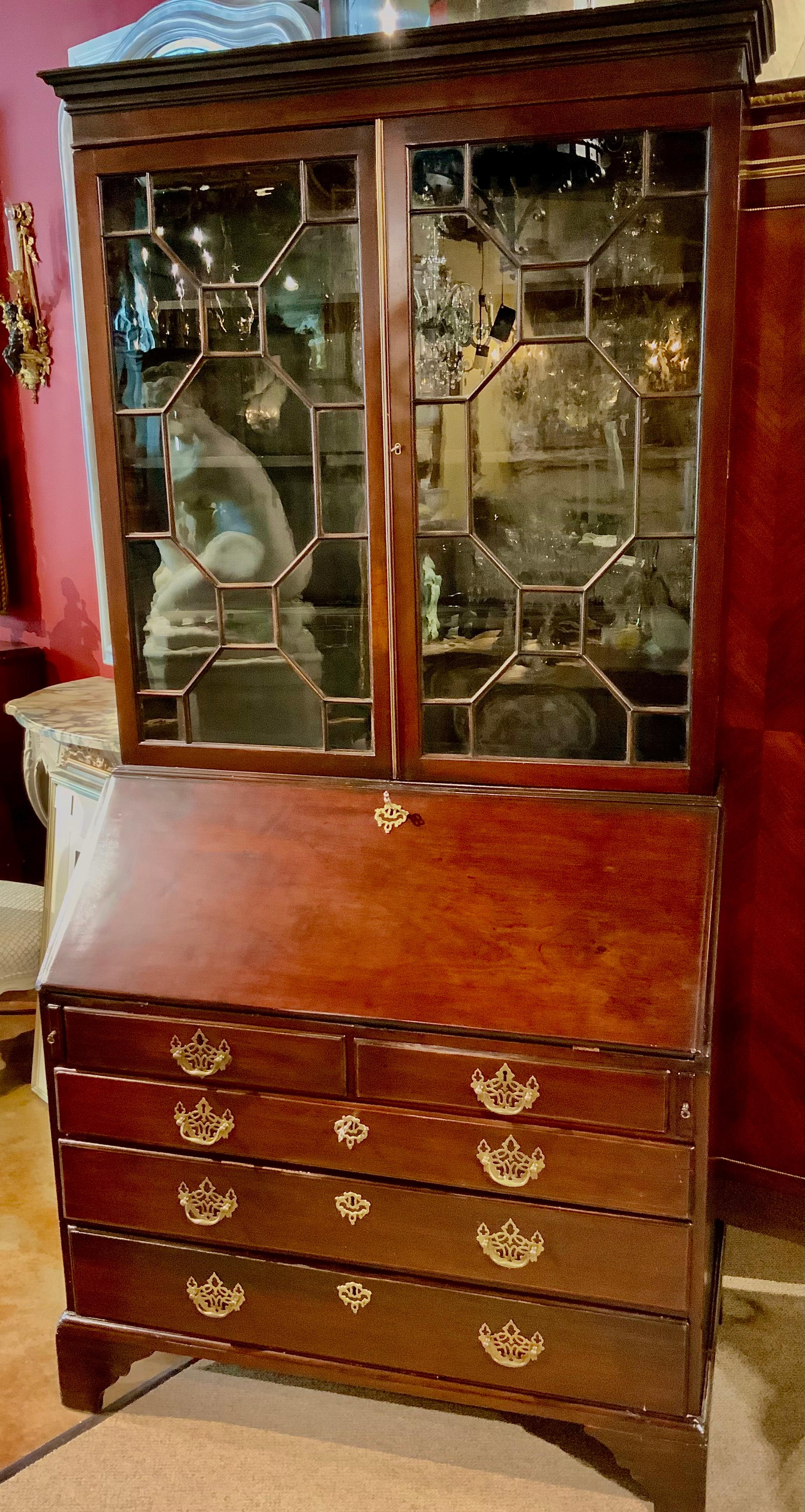This exceptional mahogany secretary is from the late
18 th c. It has hinged doors that open wide to interior
Display with shelves that are adjustable. The antique
Glass is in a geometric paned configuration. The drop
Front opens out to rest on