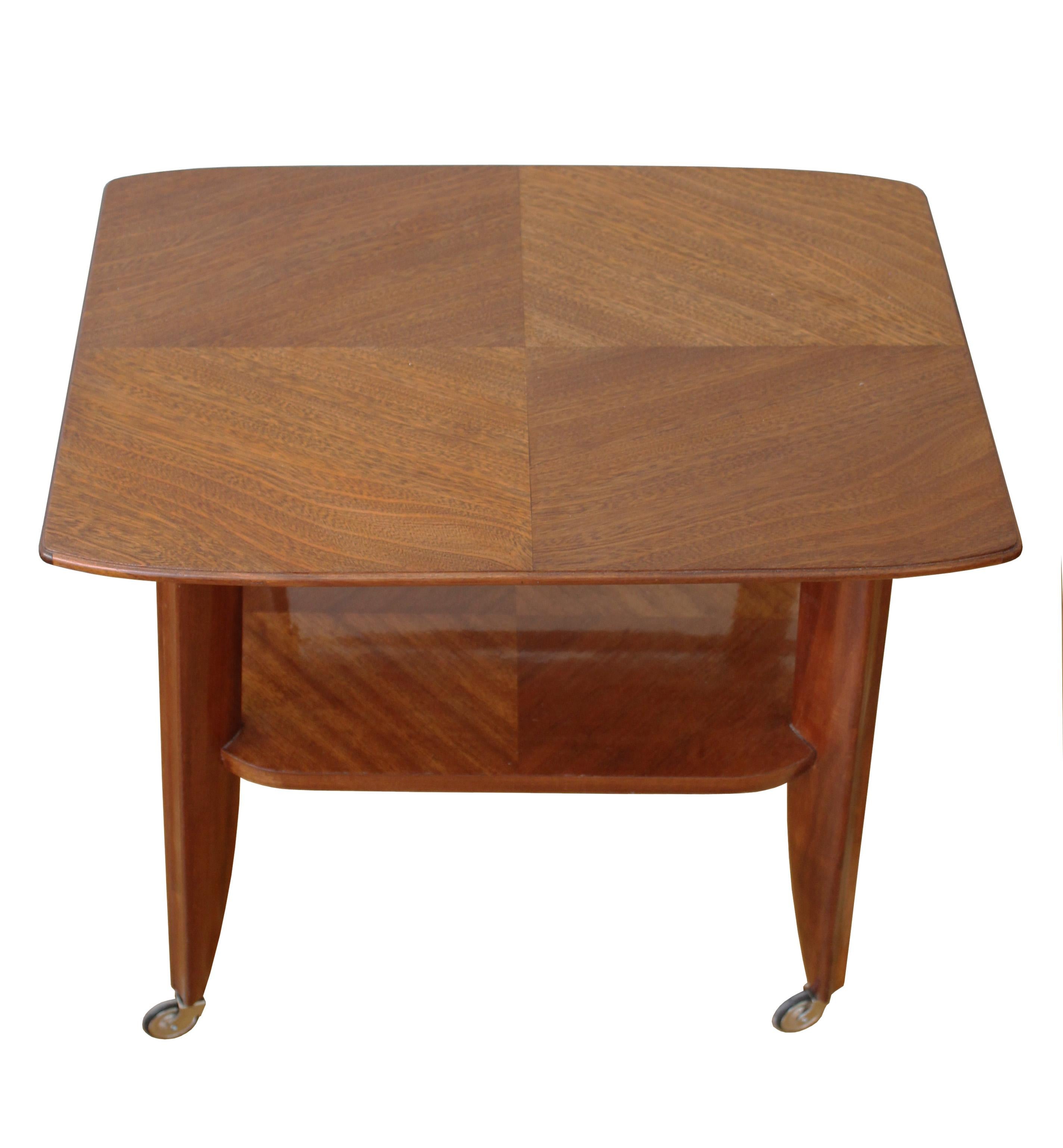 A stunning serving table on caster wheels, made entirely of mahogany wood. 

What makes this piece really stand out is the elegant gentle curves and the rich texture of the mahogany wood on both the top of the piece and the lower shelf. The top