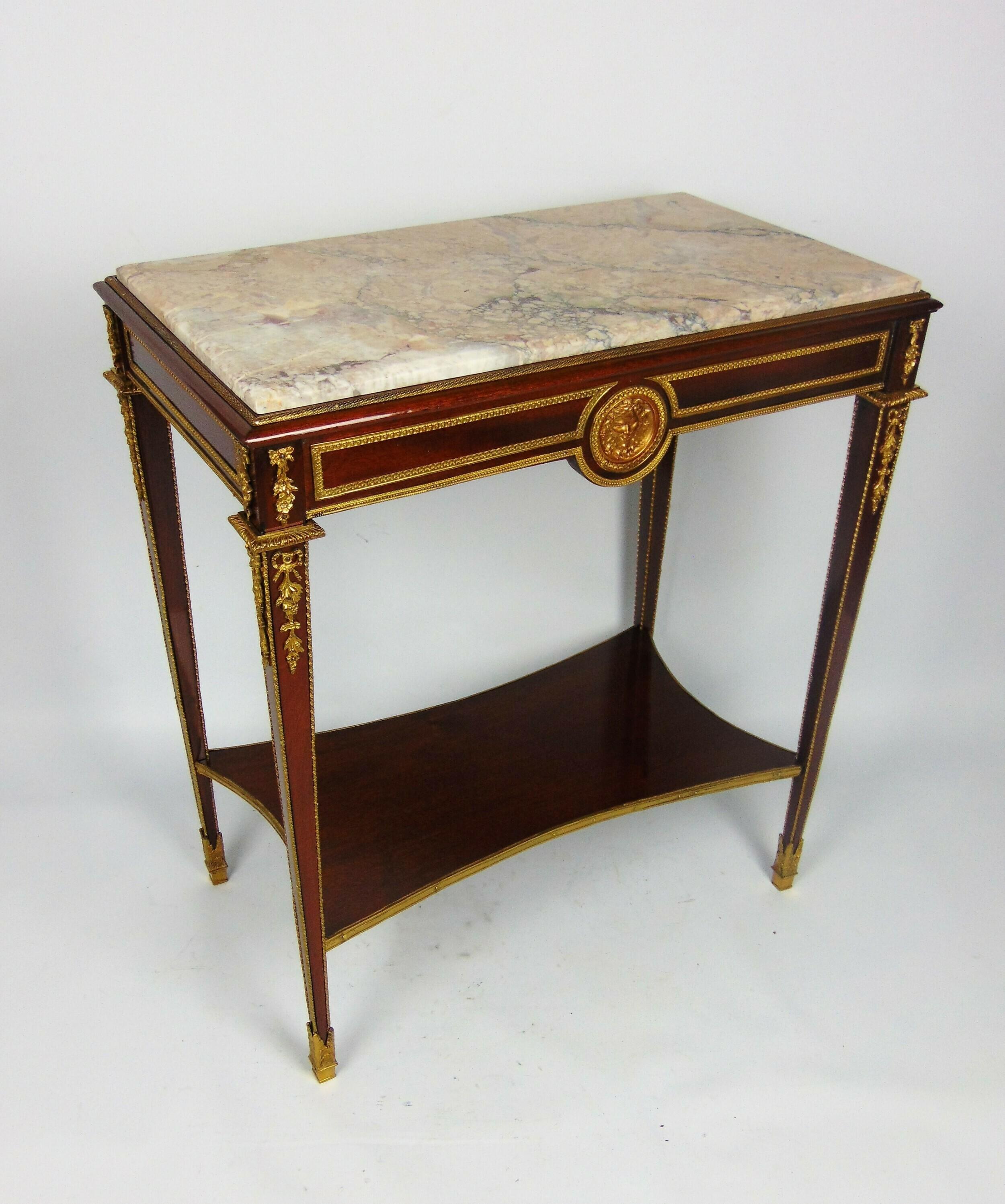 A  high quality late 19th century French Louis XV style gilt bronze mounted mahogany side table with superb Villefranche marble top sitting on rectangular base and fine ormolu mounts cast in the form of the head of Bacchus to front and back , ribbon