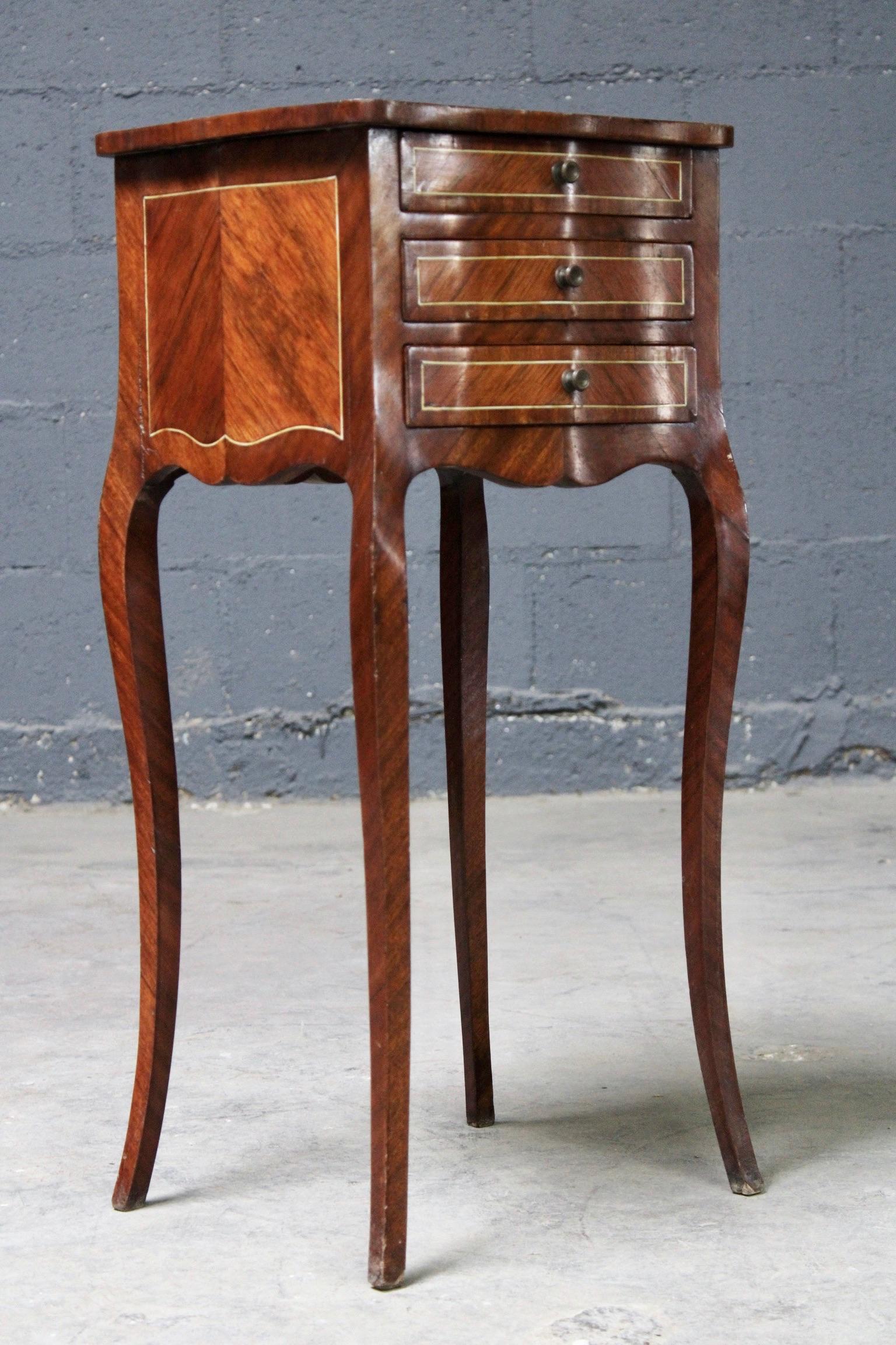 This side table has three drawers and Queen Anne legs. Inlayed mahogany creates a patterned tabletop and sides.