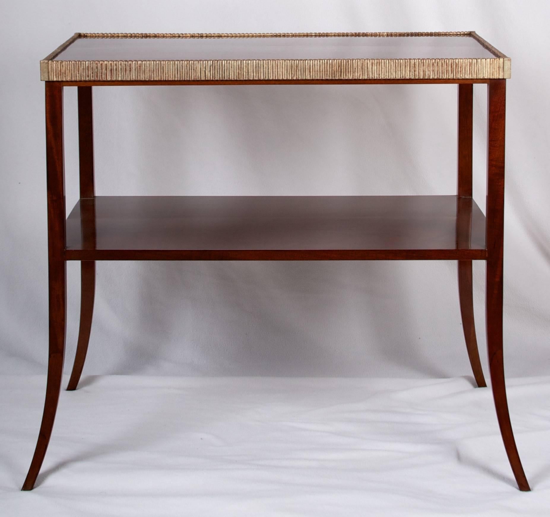 A fine mahogany side table with delicate but strong saber legs, a shelf and
wonderful gilded reed detail around the top. This table makes a wonderful side table
or bedside table or small console table.