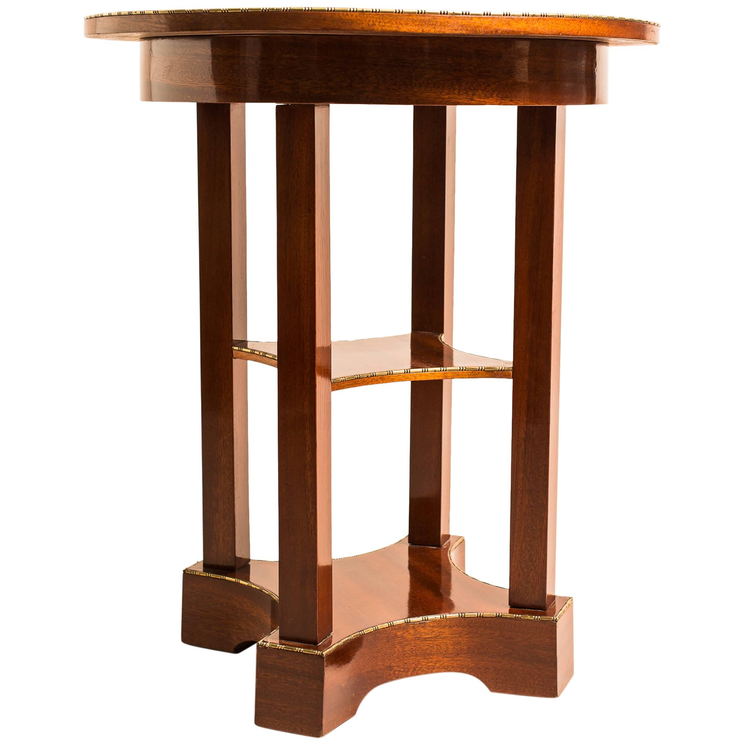 Sehr gefälliger runder österreichischer Mahagoni-Beistelltisch aus dem frühen 20. Jahrhundert, um 1910. Ein wertvolles Wiener Möbelstück, gefertigt aus feinstem Mahagoni-Furnier. Die runde Deckplatte ruht auf vier quadratischen Säulen, die auf einem