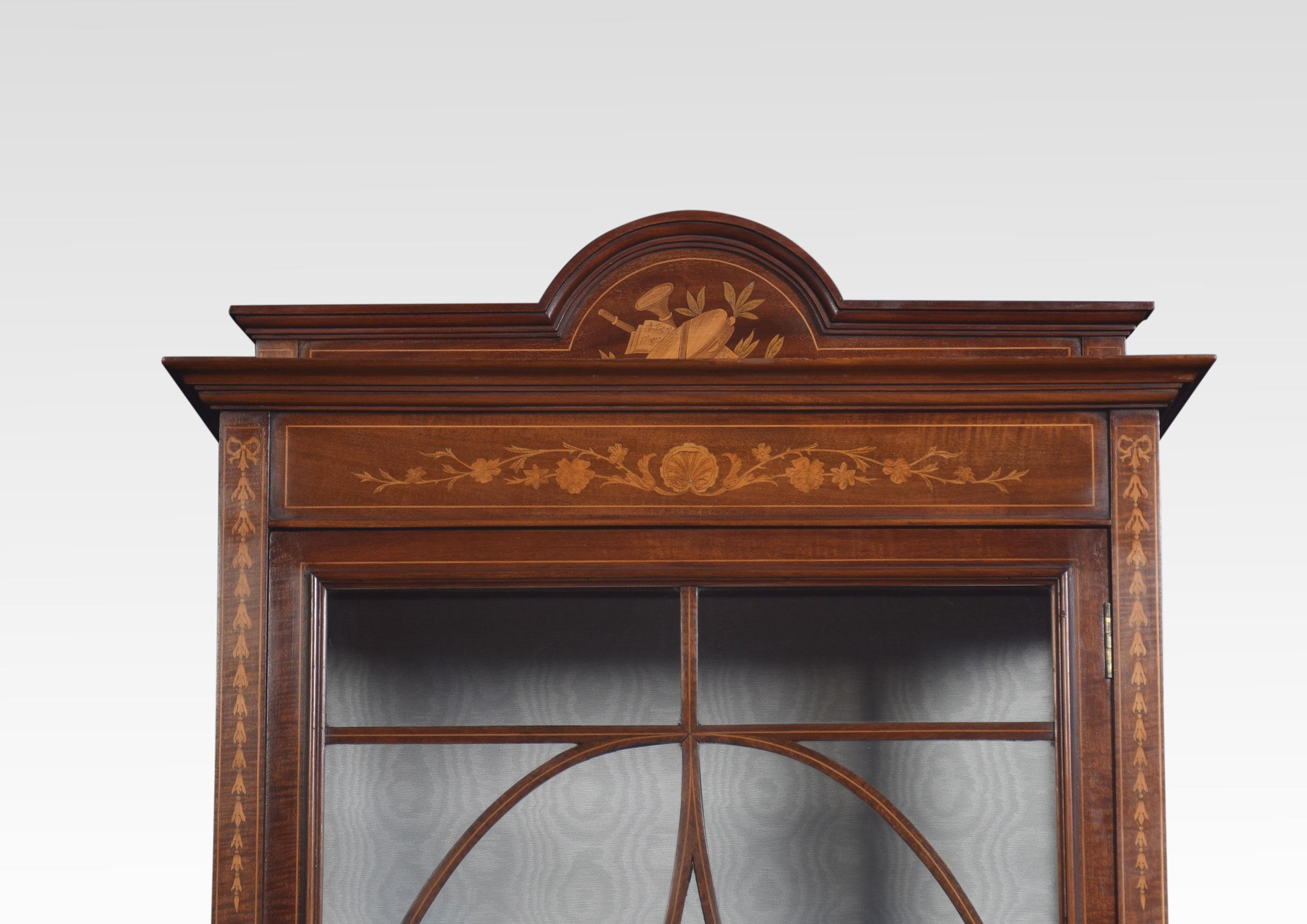 Mahogany inlaid display cabinet, the raised back with musical inlaid detail above large single glazed door opening reveal upholstered interior with two glazed shelves. All raised up on square section tapering legs terminating in spade