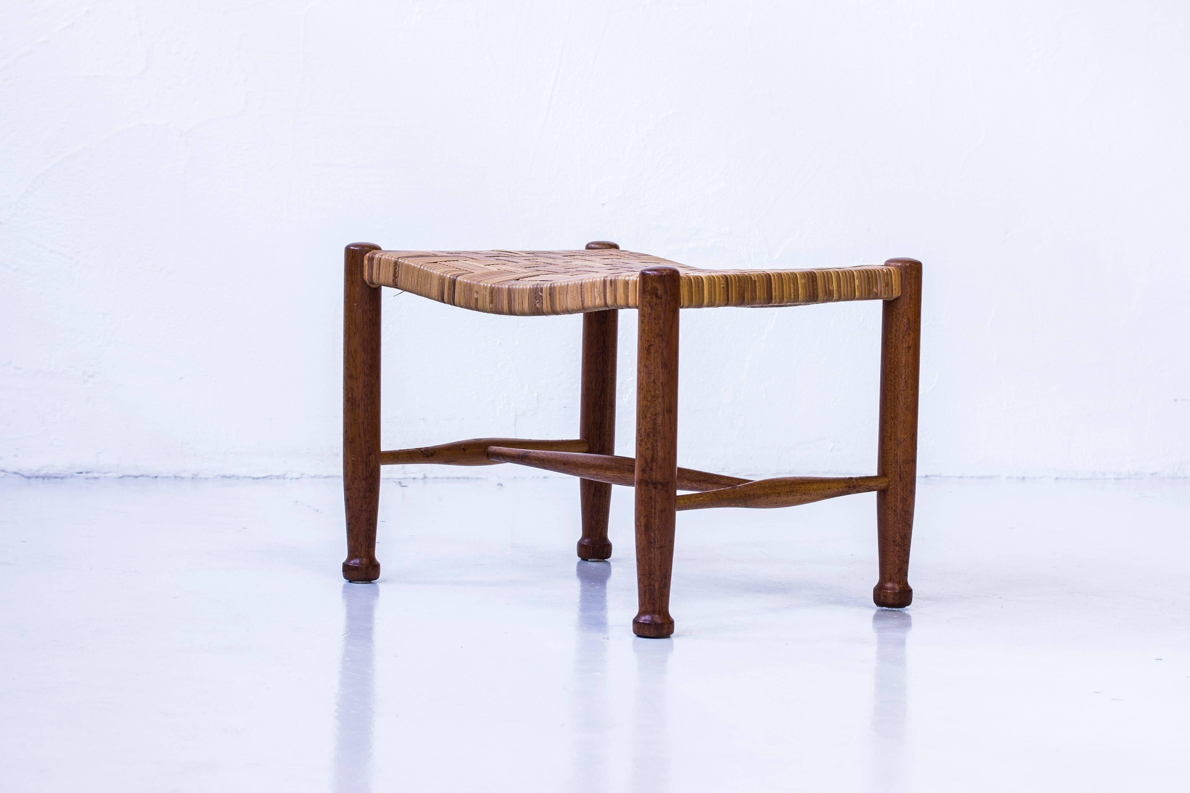 Stool designed by Josef Frank. Produced in Sweden by Firma Svenskt Tenn during the 1950s. Made from solid mahogany with original rattan seat in perfect condition with beautiful patina. Excellent condition with few signs of wear.
 