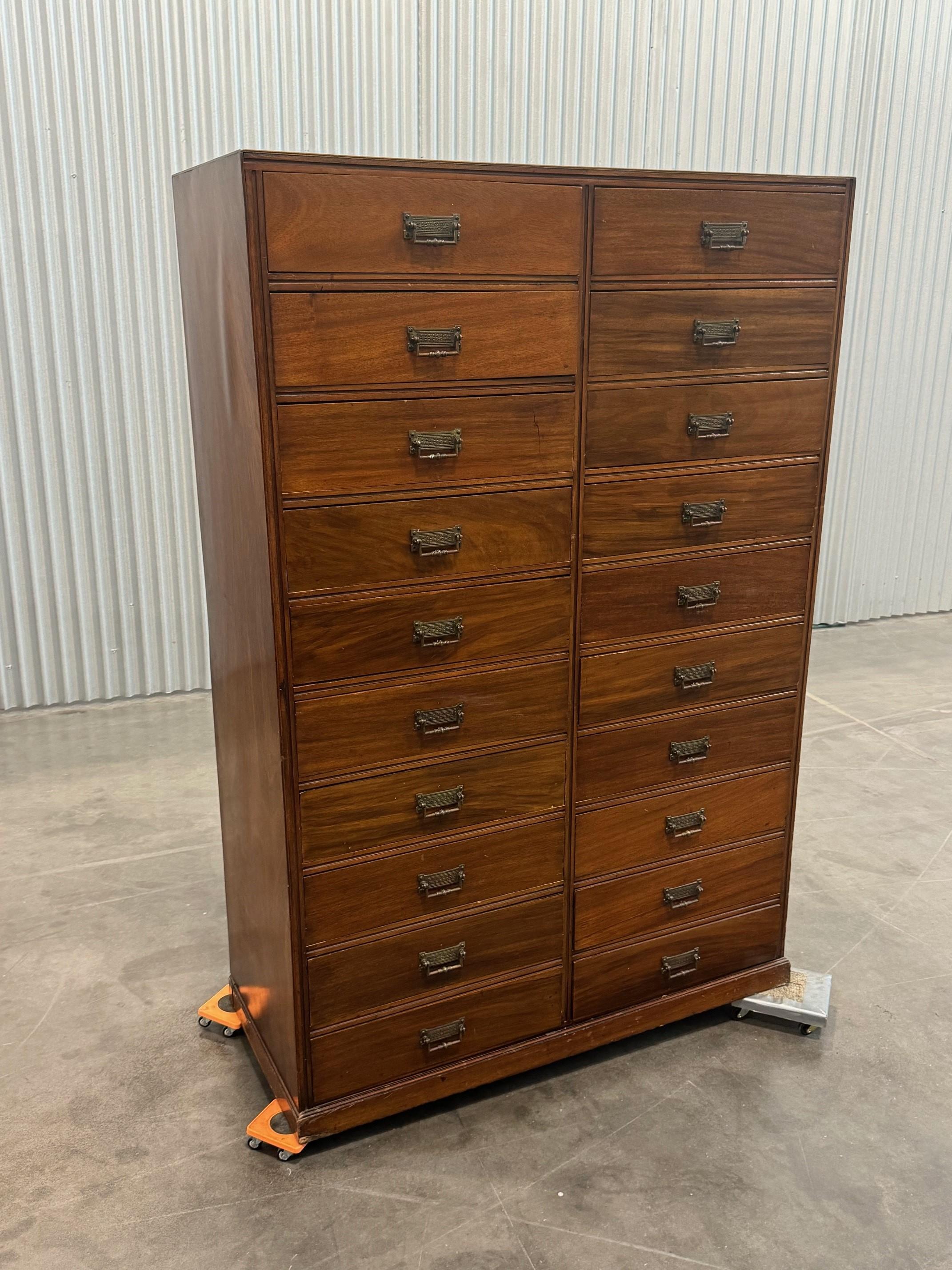 Splendida cassettiera a fronte dritta in mogano della fine del XIX secolo, dotata di due banchi verticali di dieci cassetti, ciascuno dotato di maniglie in ottone dell'Aesthetic Movement con decorazione a fogliame, ogni cassetto è affiancato da una