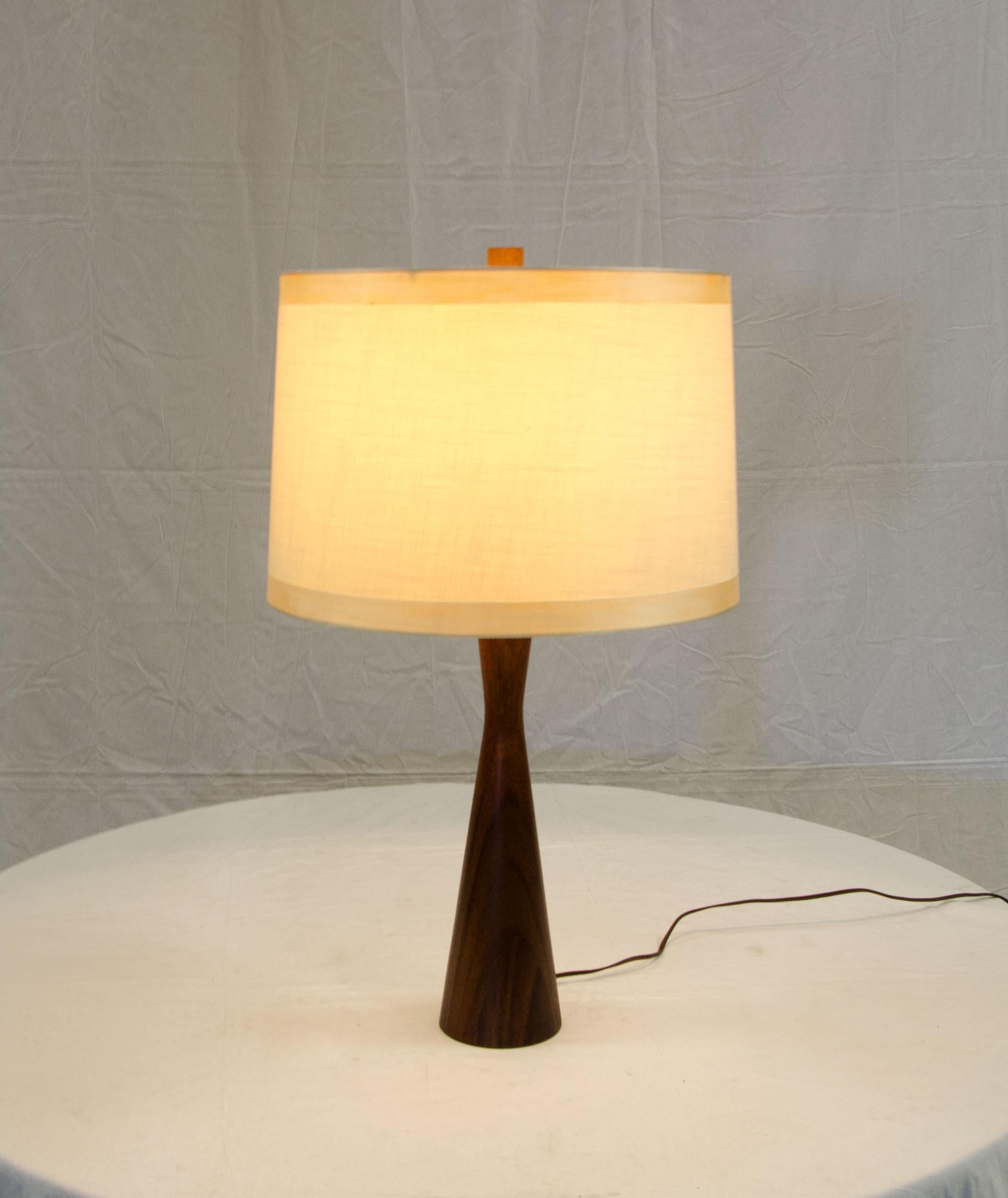 Medium size stylish table lamp with a mahogany tapered base and a replacement shade. The lamps finial is walnut. The shade measures: 11