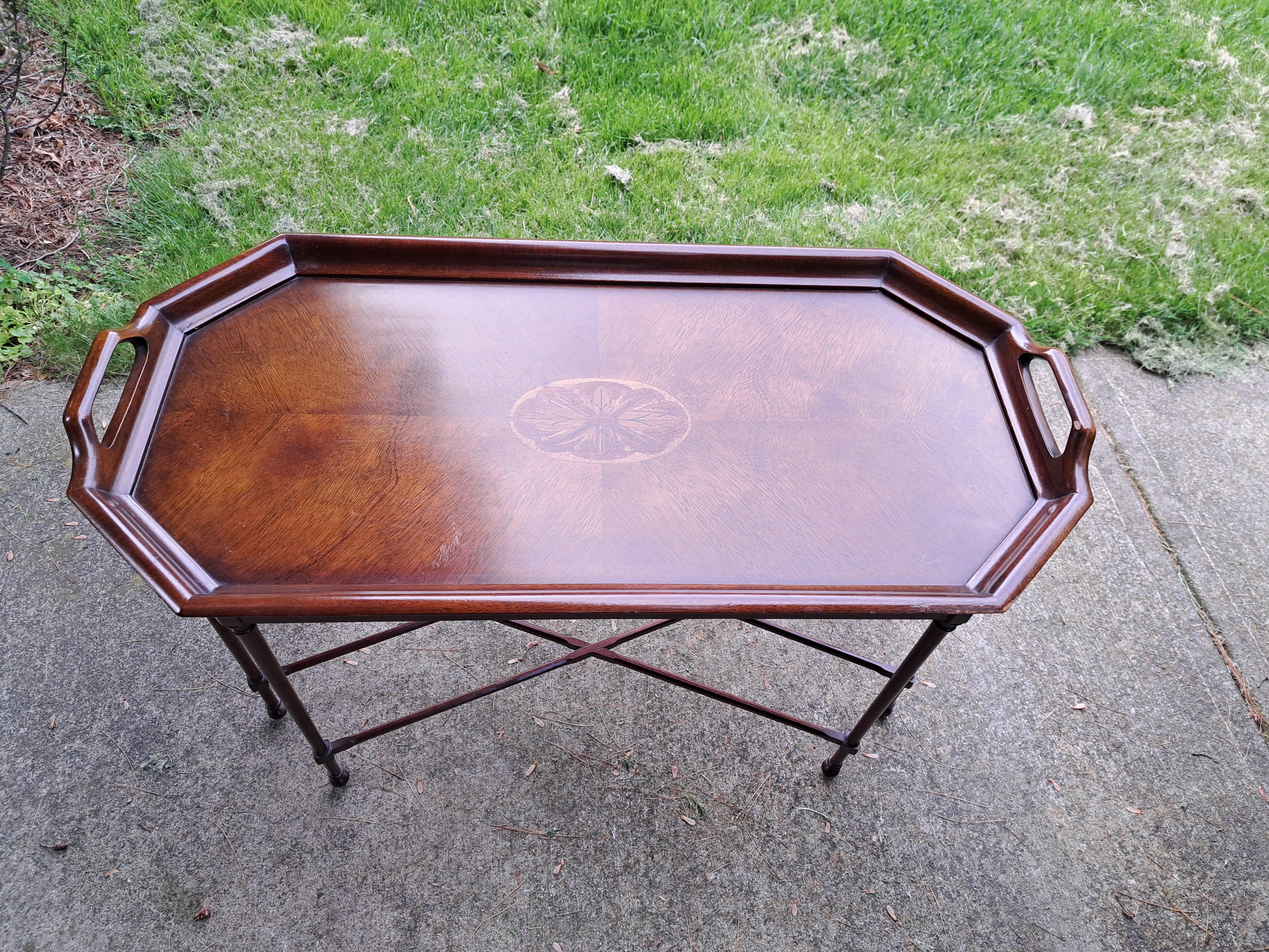 Rectangular mahogany coffee table with handles and an elegant thin network of legs.