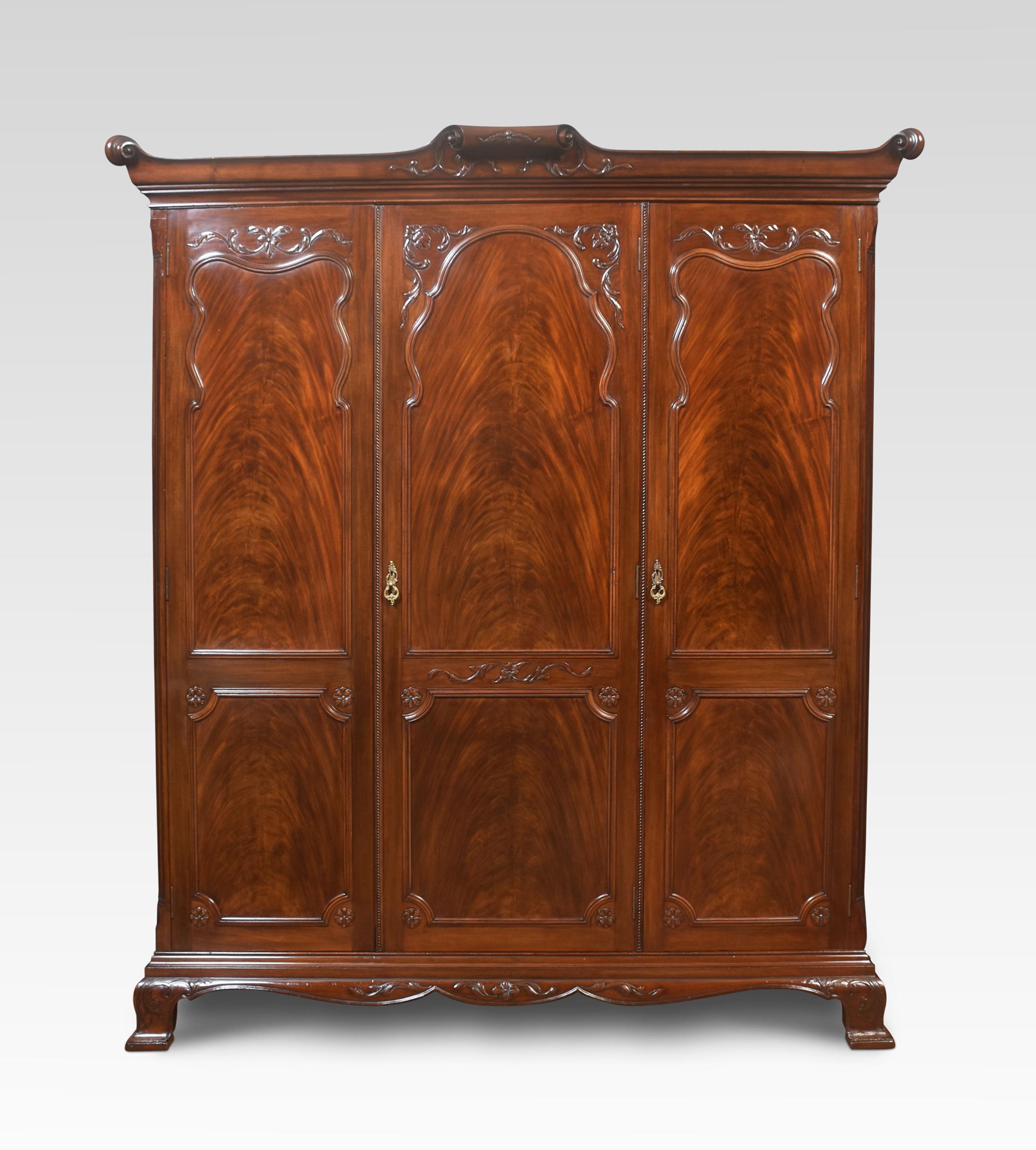 Mahogany three-door wardrobe, the moulded scrolling cornice above three long well figured panelled mahogany doors, opening to reveal large hanging area and shelves above. All raised up on plinth base terminating in bracket feet.
Dimensions
Height