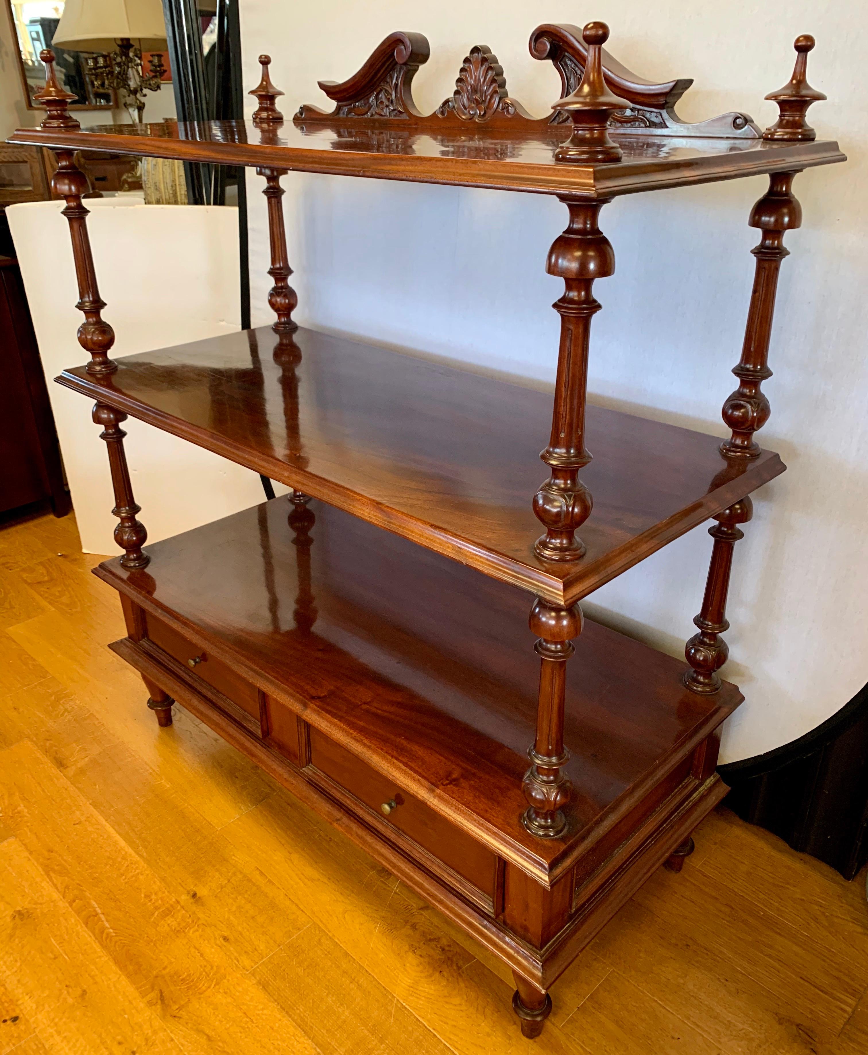 A superb mahogany étagère, server or set of shelves, in the William IV style featuring a carved serpentine back splash and three shelves over two drawers. ABC carpet.