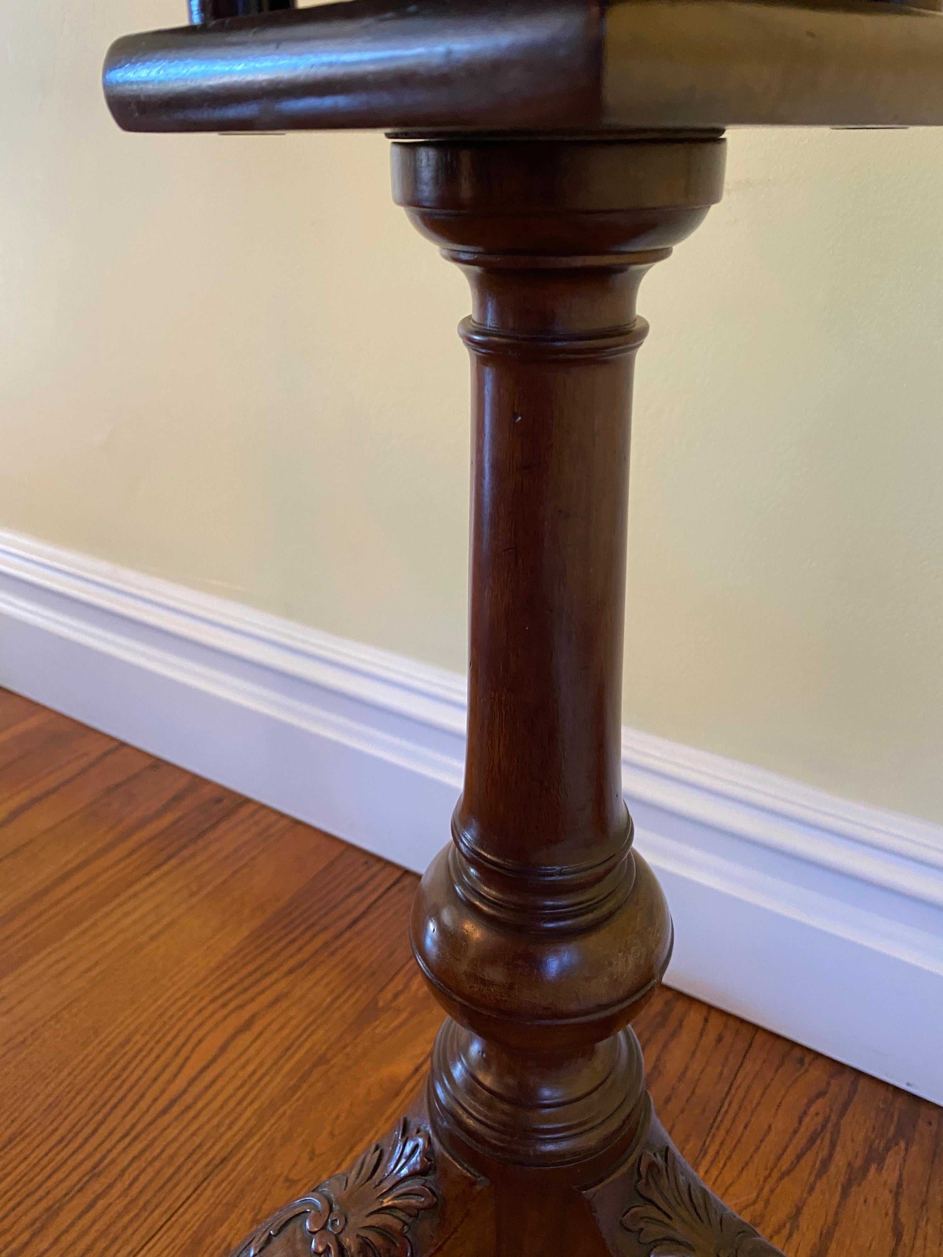 A George III scalloped top mahogany tilt-top tripod table.

Scalloped top raised on a birdcage support above a column standard 
with turned base. Standard raised on three acanthus headed cabriole legs 
terminating in ball and claw feet.