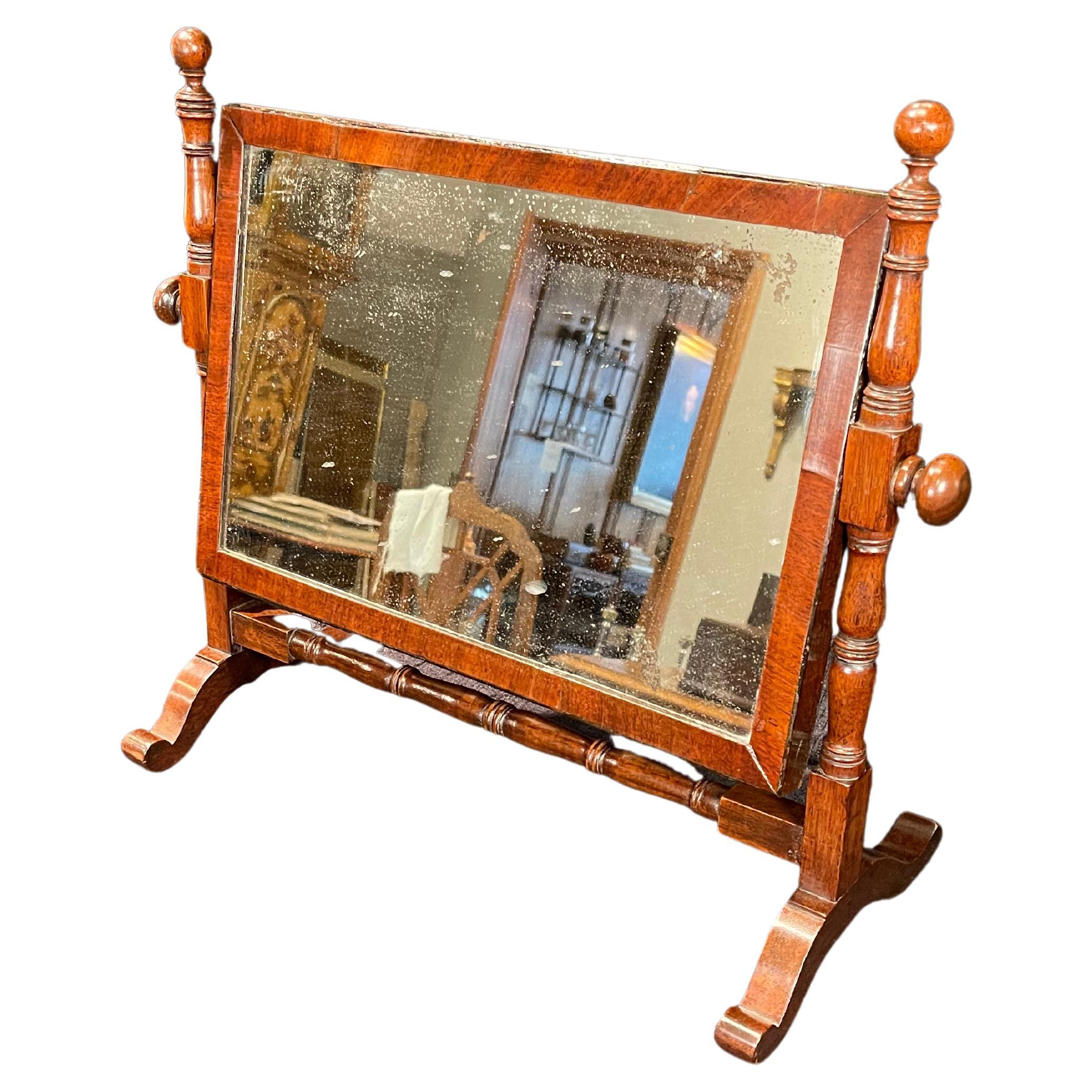 Mahogany Tilting Dressing Mirror , the mirror on a turned frame. Mirror tilts to desired position. The antique frame with period mirror lightly antiqued in appearance. The stand is topped with ball finials & knobs.