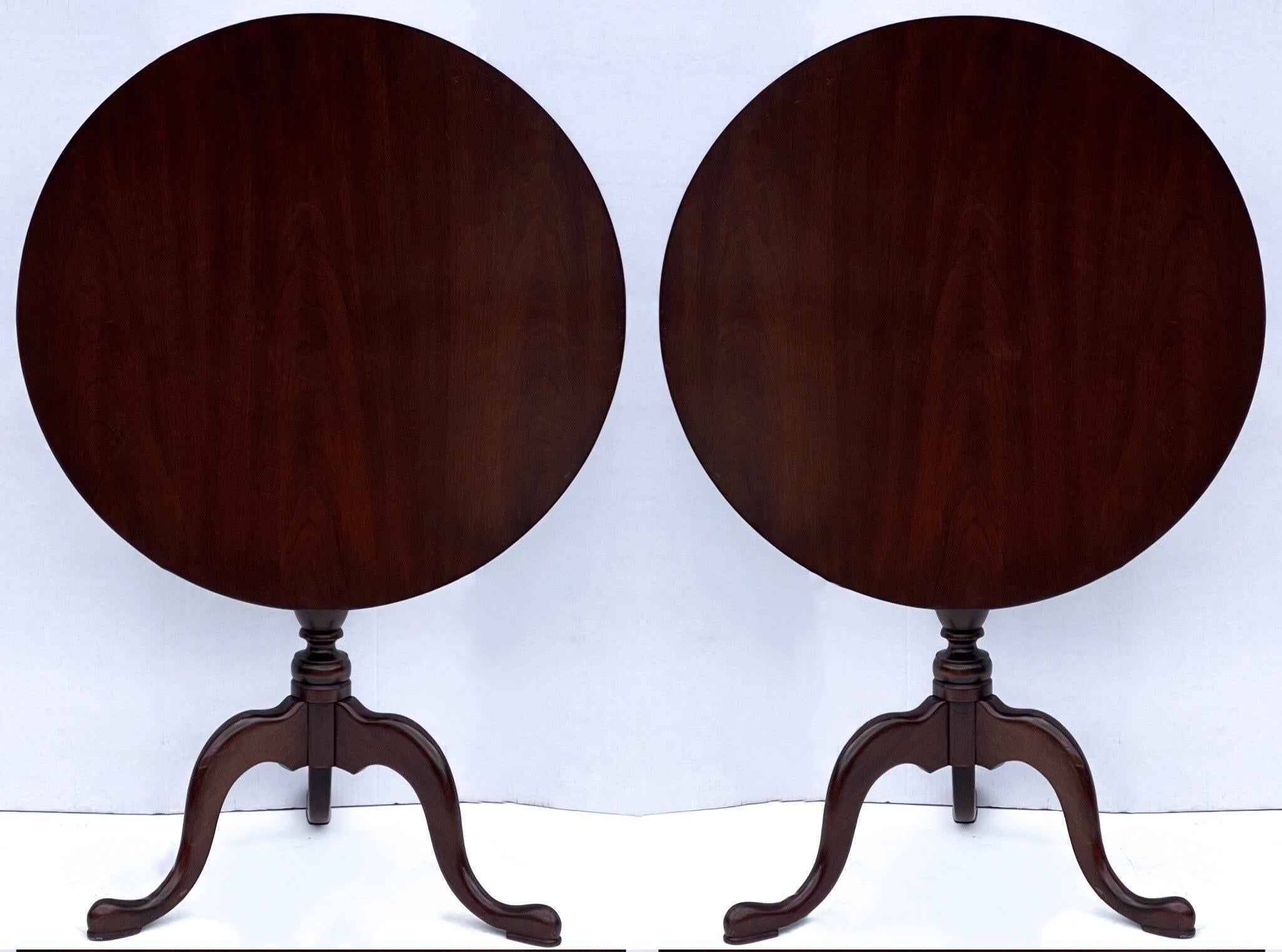 These are timeless! This is a pair of round carved mahogany tilt-top side tables created by Baker Furniture for Hitchcock. They are in very good condition. They are 29”H in the vertical position.