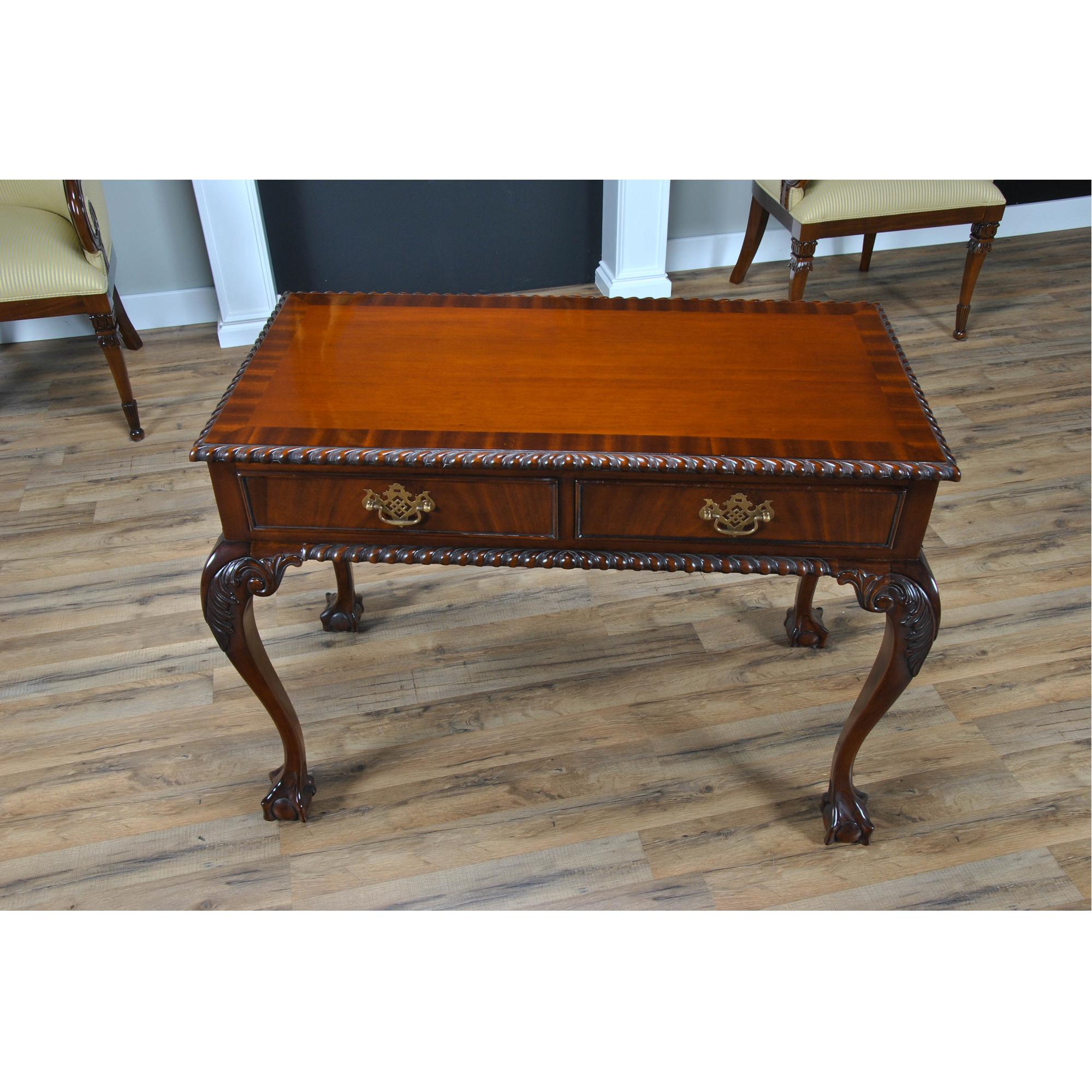 A Chippendale style Mahogany Two Drawer Console with a banded mahogany top, a gadrooned (rope edged)  molding over top a frieze with two dovetailed drawers which feature solid brass pulls. The cabriole legs of our Mahogany Two Drawer Console are