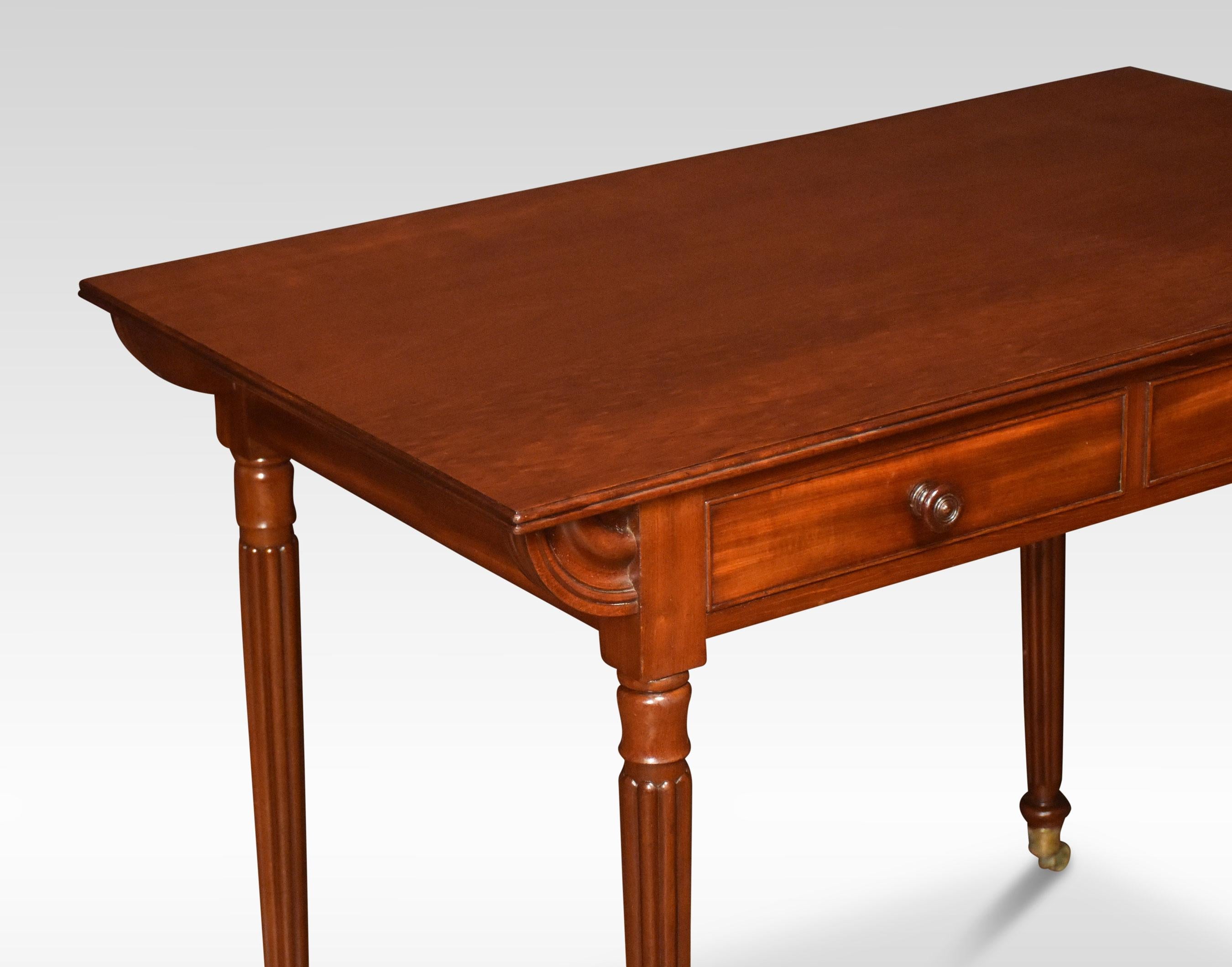 Mahogany writing / side table, the moulded rounded oblong top, two frieze drawers and false draws to opposing side with turned mahogany handles, raised on reeded turned tapering legs with brass toes and castors.

Dimensions:

Height 30