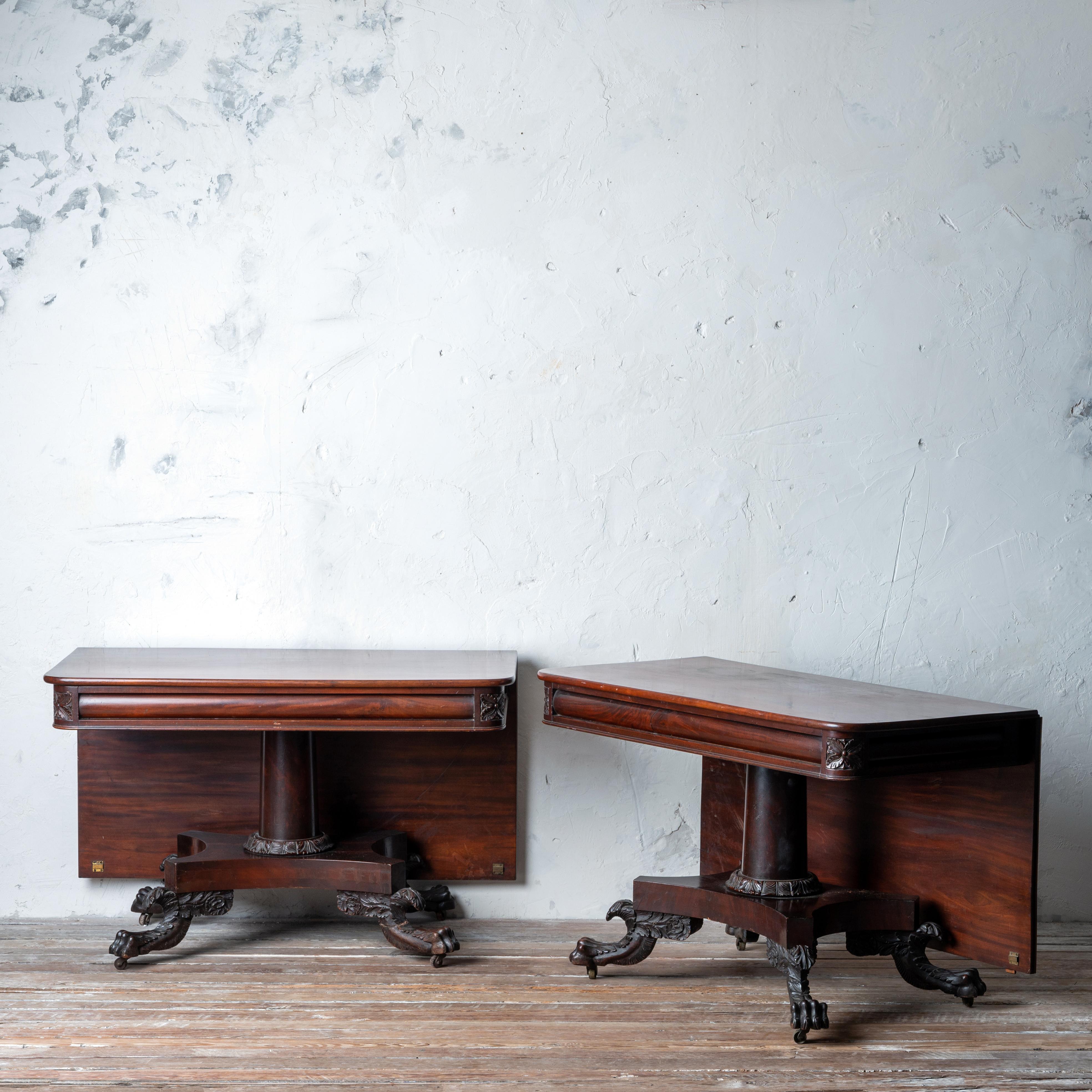 Table de banquet ou de salle à manger en deux parties en acajou sculpté de style classique américain, probablement de l'atelier Quervelle, Philadelphie, C.I.C. 

Les plateaux pivotants à feuilles tombantes, les piédestaux cylindriques sur des bases