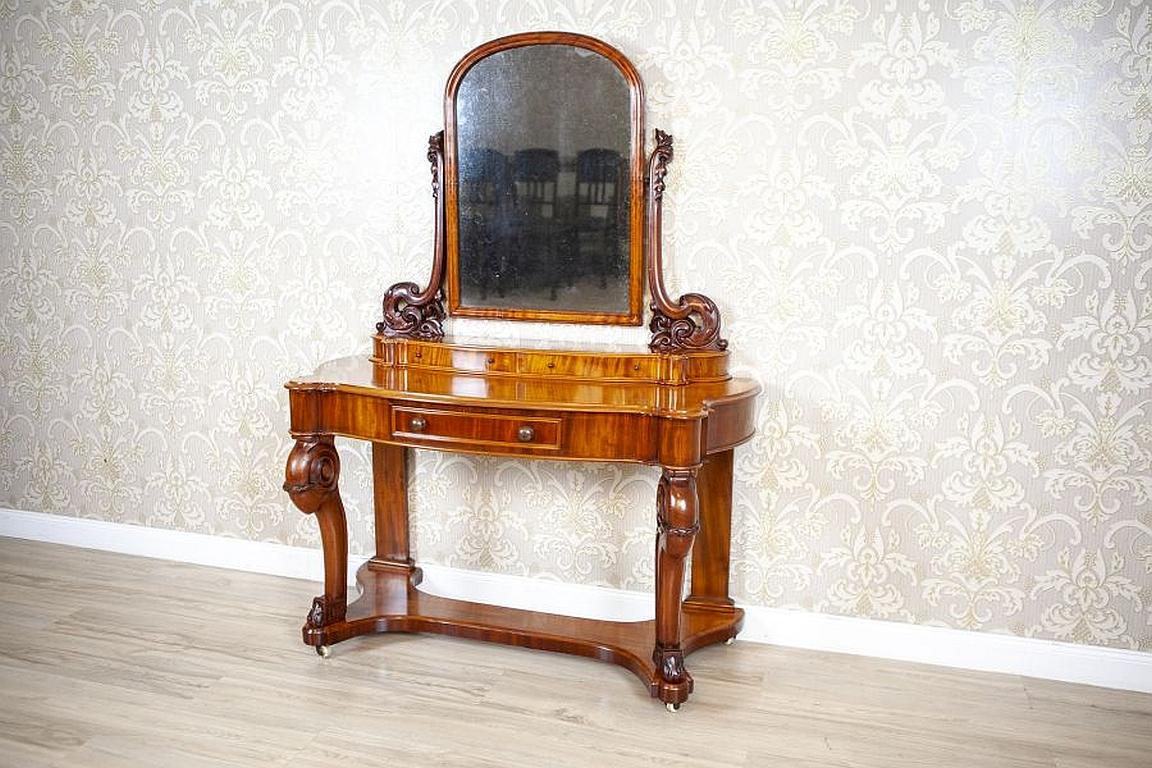 Elegant Mahogany Vanity Table in Light Brown From the Late 19th Century

We present you an elegant and exquisite Victorian vanity table composed of an upper section with the original mirror fixed on carved arms, and placed on an add-on unit with two