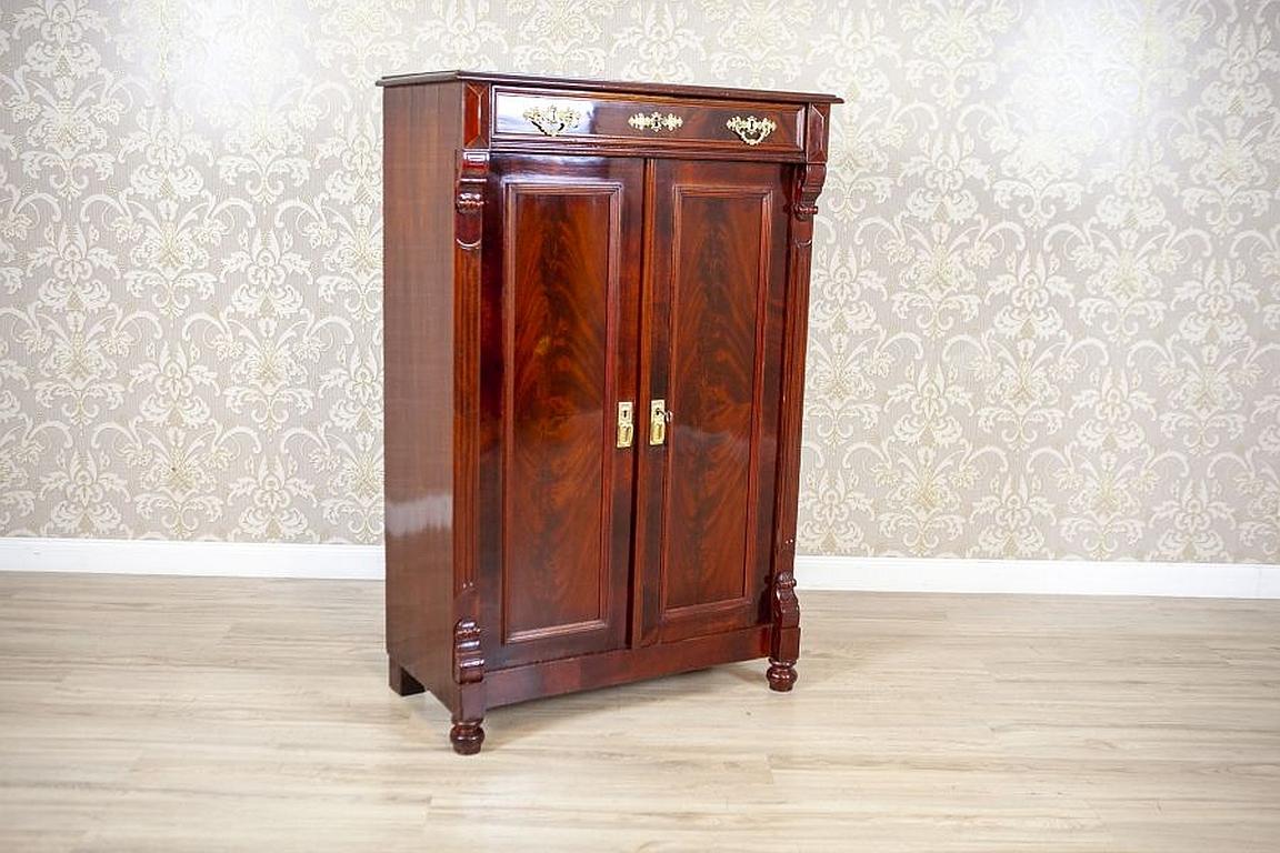 Antique Brown Vertico Cabinet with Brass Details, circa 1880

We present you a cabinet in the type of vertico. This piece of furniture is of a straight form, with a two-door corpus with four shelves and a drawer locked with a key, which is decorated