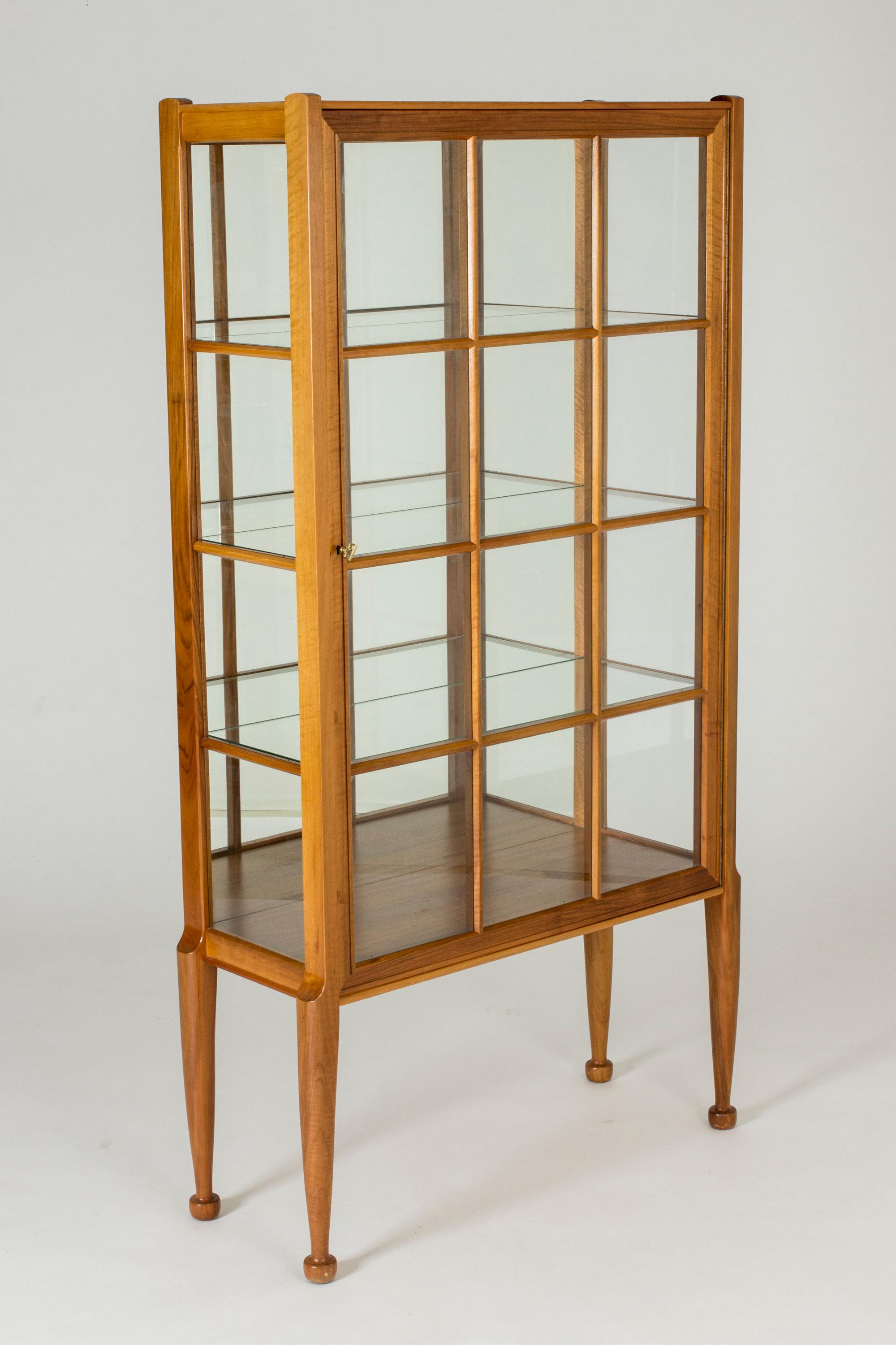 Beautiful, rare vitrine cabinet by Josef Frank, made in mahogany and glass. Mirrored glass reflects objects placed on the clear glass shelves. Sculpted feet, elegant smooth lines.