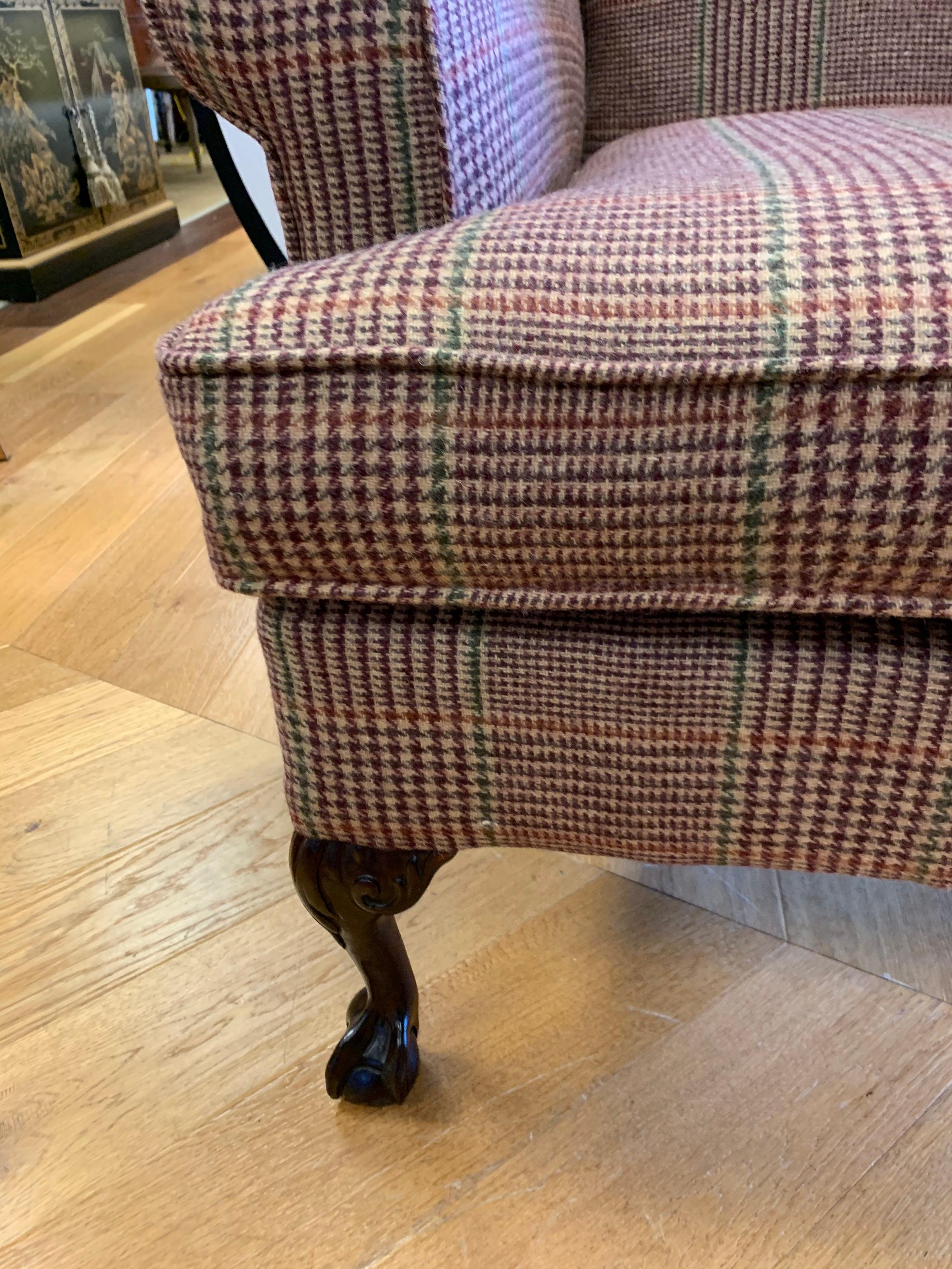 Magnificent Georgian antique wingback chair that has been newly reupholstered in the Ralph Lauren
tartan wool plaid fabric. The tartan plaid fabric melds perfectly with the dark, rich mahogany ball and claw legs. One of three special chairs we are