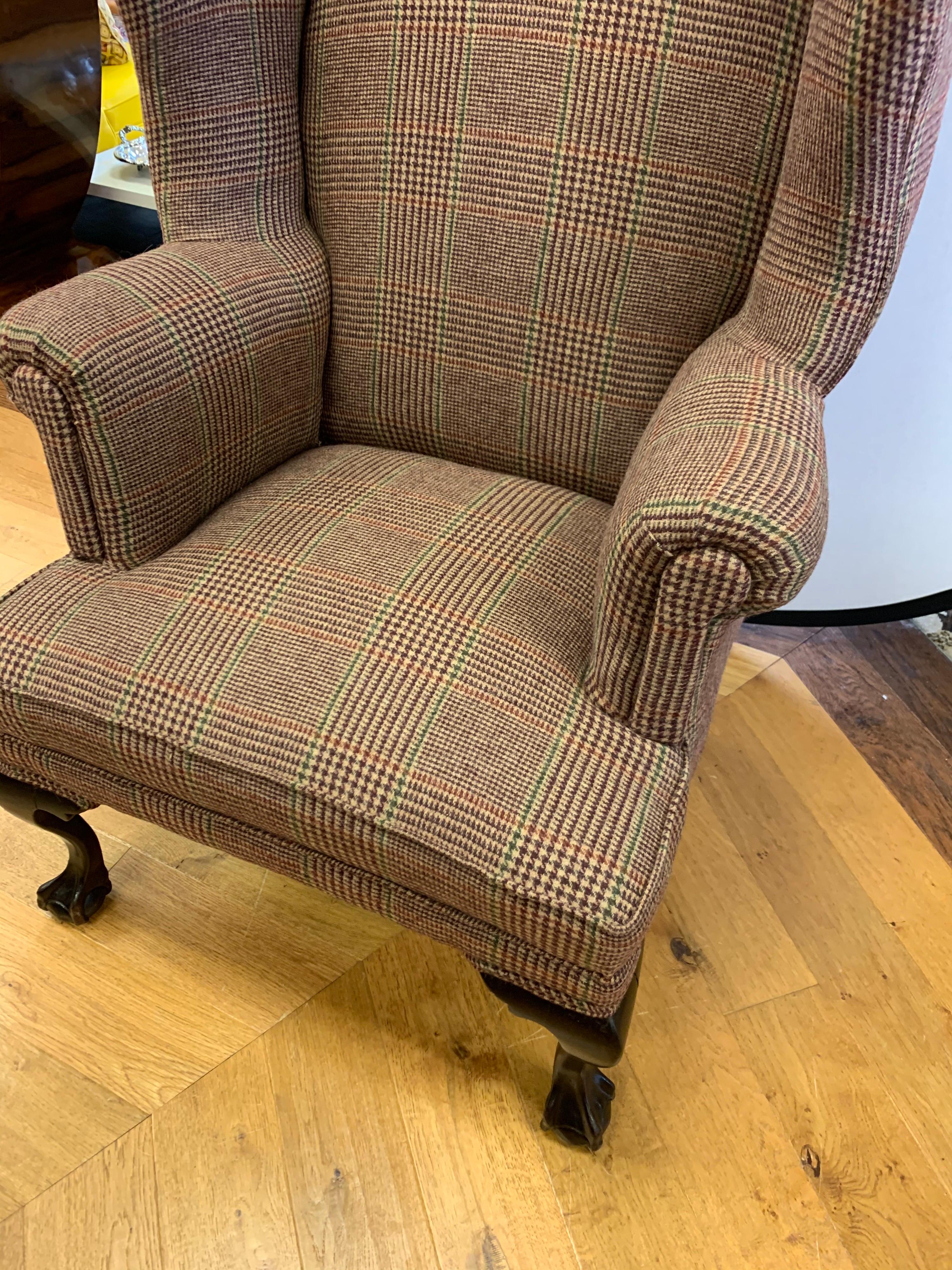 Magnificent Georgian antique wingback chair that has been newly reupholstered in the Ralph Lauren
tartan wool plaid fabric. The tartan plaid fabric melds perfectly with the dark, rich mahogany ball and claw legs.