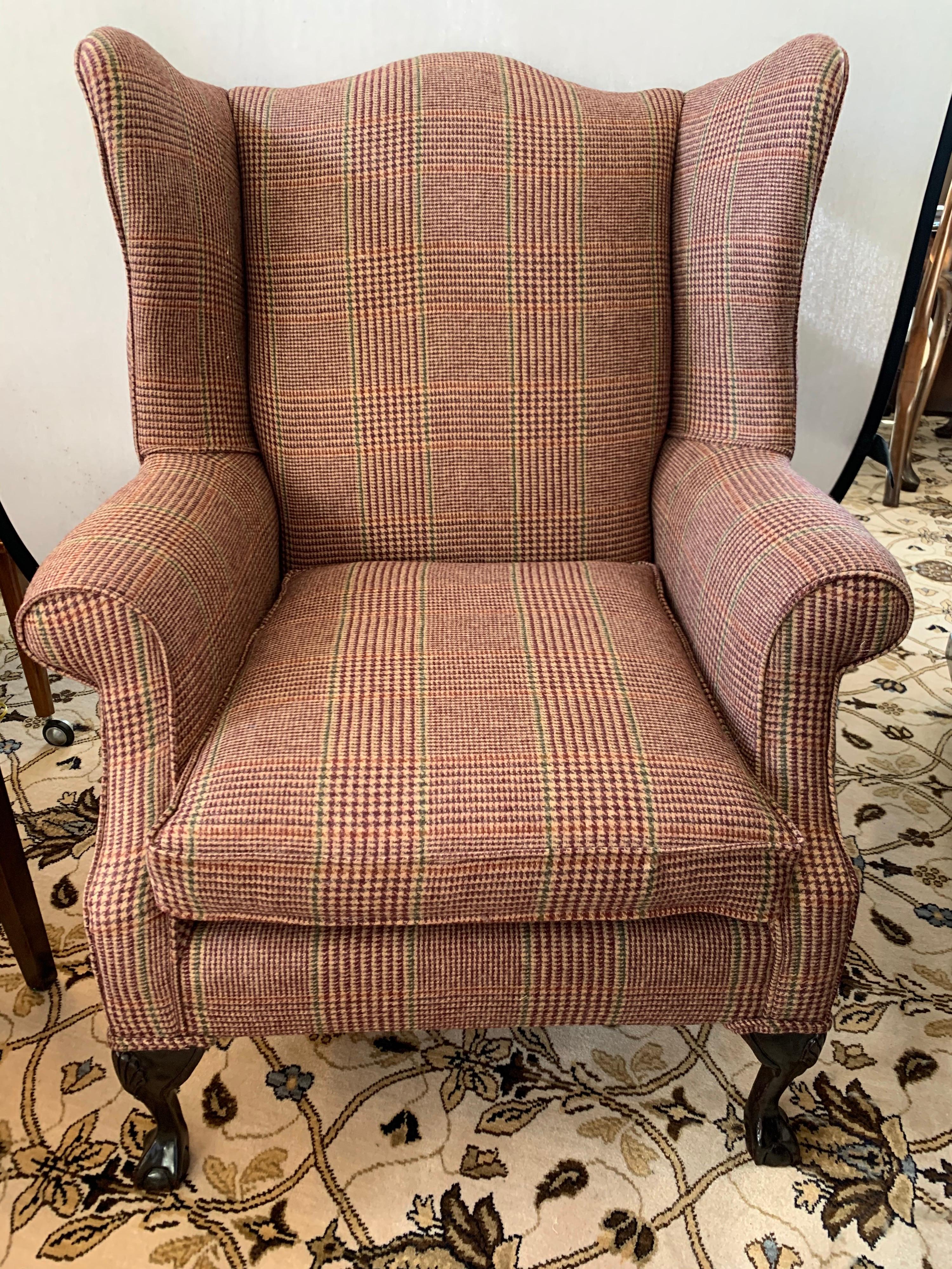 Magnificent Georgian antique wingback chair that has been newly reupholstered in the Ralph Lauren tartan wool plaid fabric. The tartan plaid fabric melds perfectly with the dark, rich mahogany ball and claw legs. One of three special chairs we are