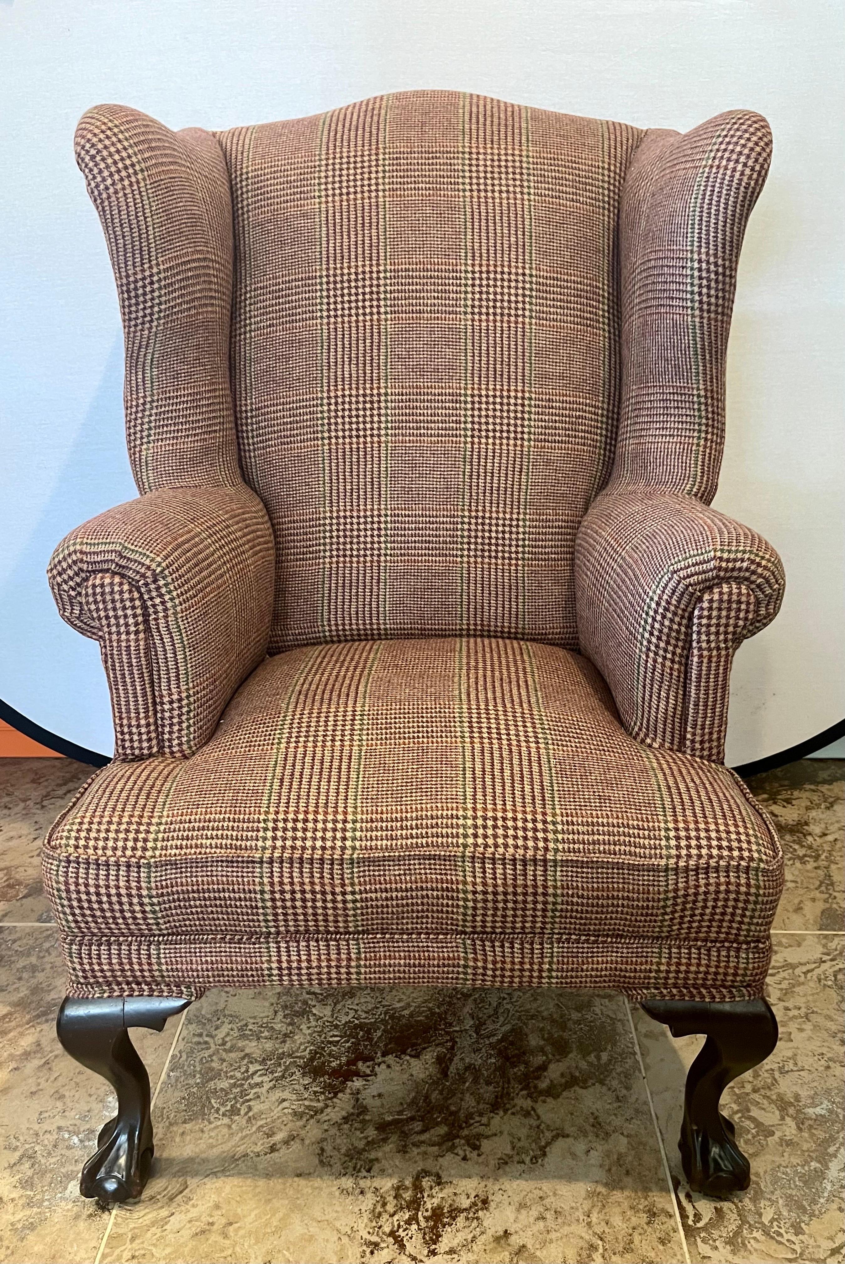 Magnificent Georgian antique wingback chair that has been newly reupholstered in the Ralph Lauren
tartan wool plaid fabric. The tartan plaid fabric melds perfectly with the dark, rich mahogany ball and claw legs.