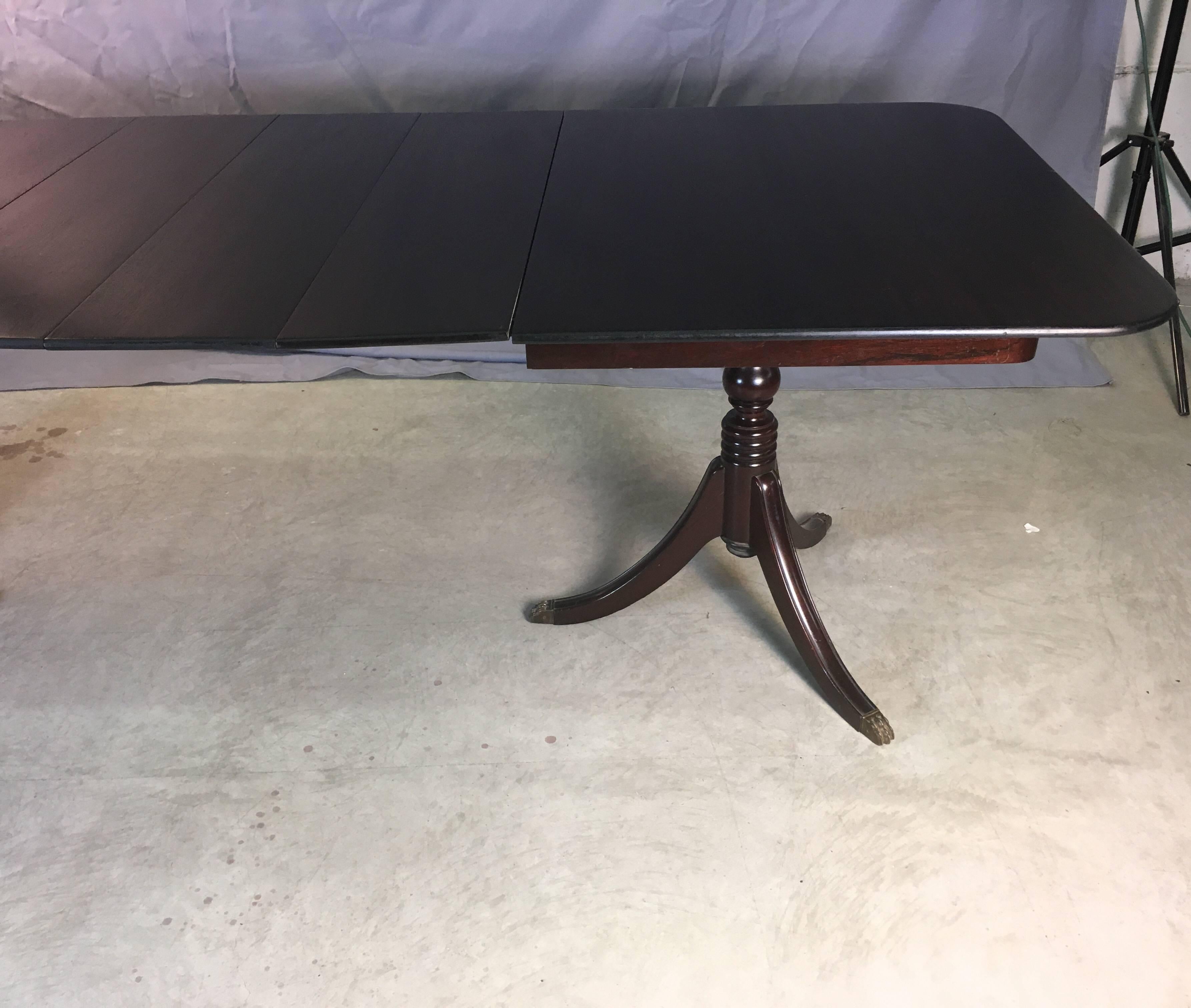 Vintage mahogany wood banquet dining room table with five boards. The feet have brass claw accents. The table fully open 102 inches. Boards 10.5 inches W. Unmarked. Tabletop and boards have been restored.