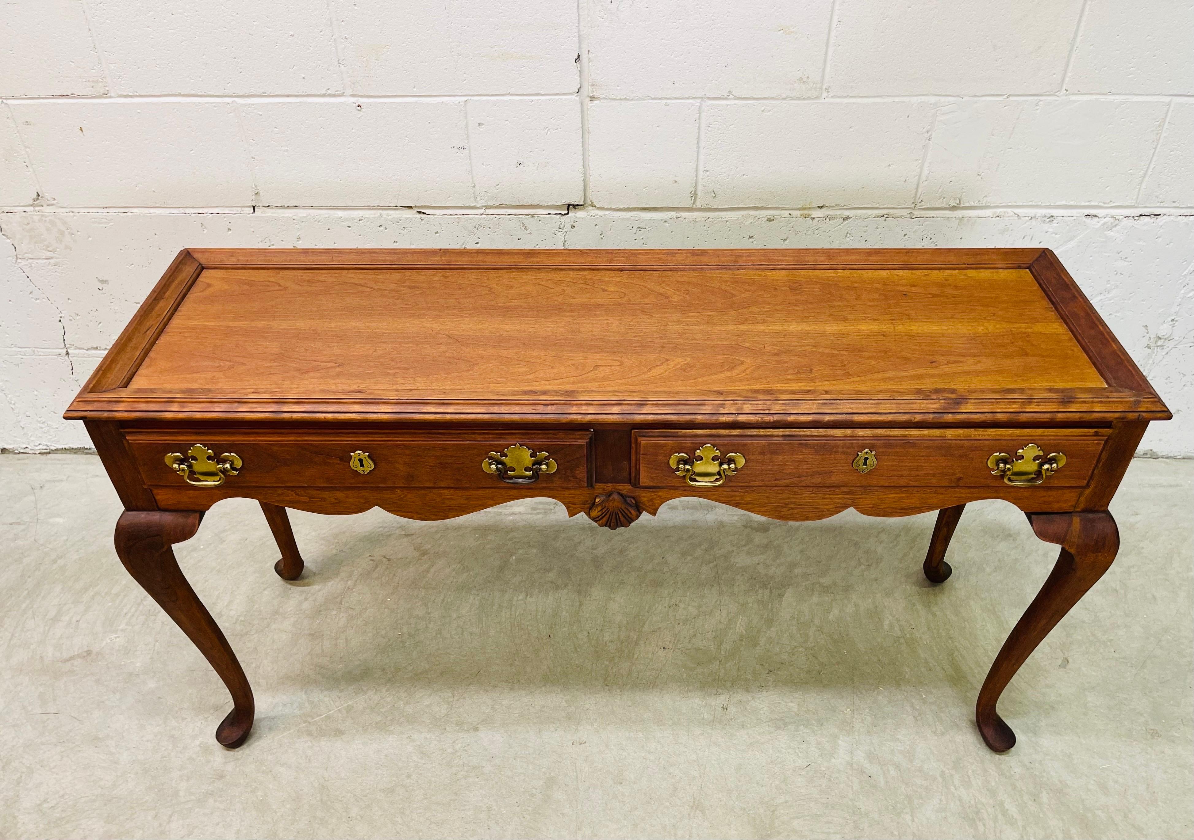 Vintage 1980s mahogany wood two drawer console table. The table has two drawers for storage and Queen Anne style cabriole legs. Back is finished and could be displayed. Brass brass pulls and key hole accents. Excellent refinished condition. No marks.