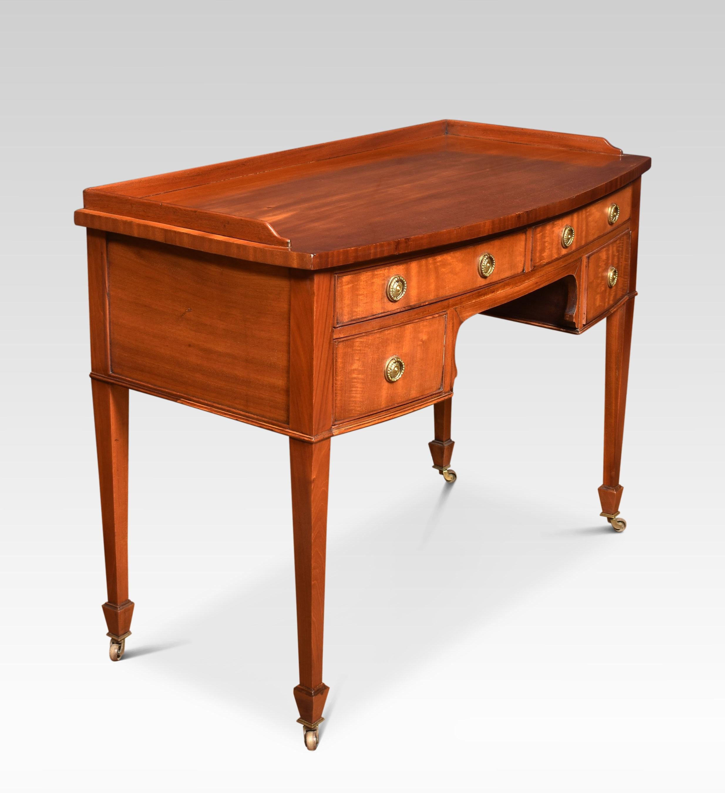 Mahogany writing table, the rectangular top with a raised three-quarter gallery. Above an arrangement of drawers with brass handles. All raised on four tapering supports terminating in brass casters.
Dimensions
Height 32 inches height of kneehole