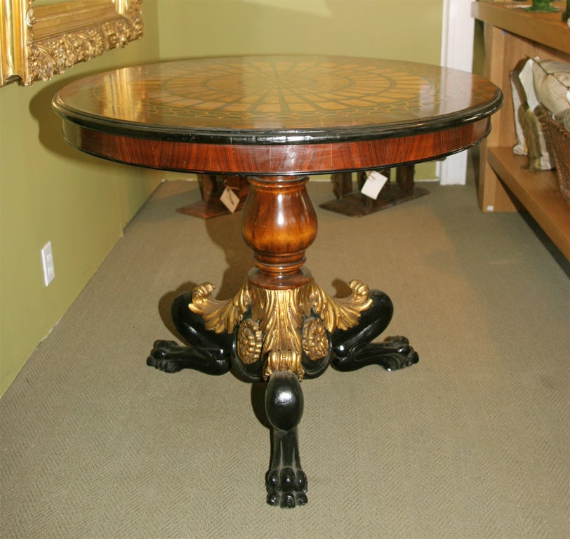 Inlaid wood parquetry design top with gilt and ebonized wood base.
  